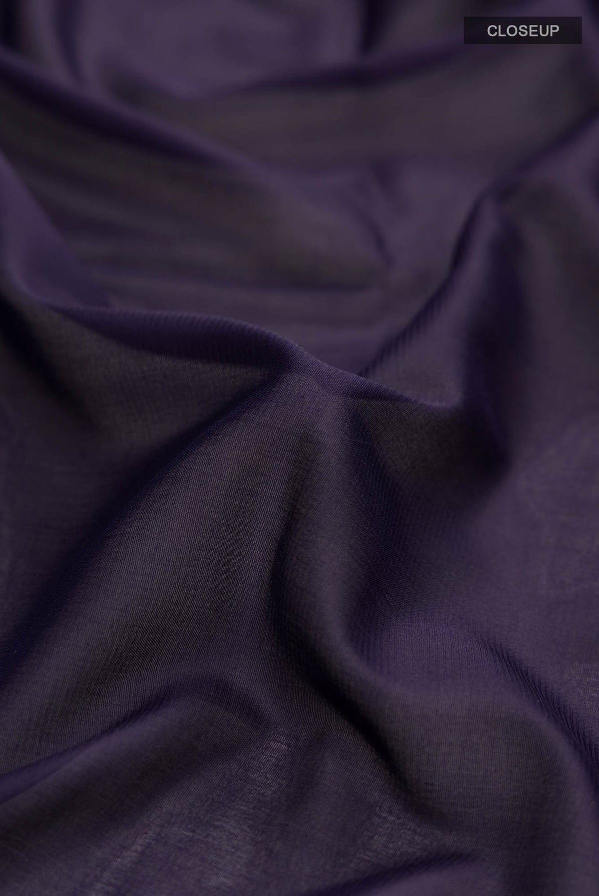Close up of Navy Blue Blended Crepe Saree with Plain Body and Zari Border.  displaying folds
