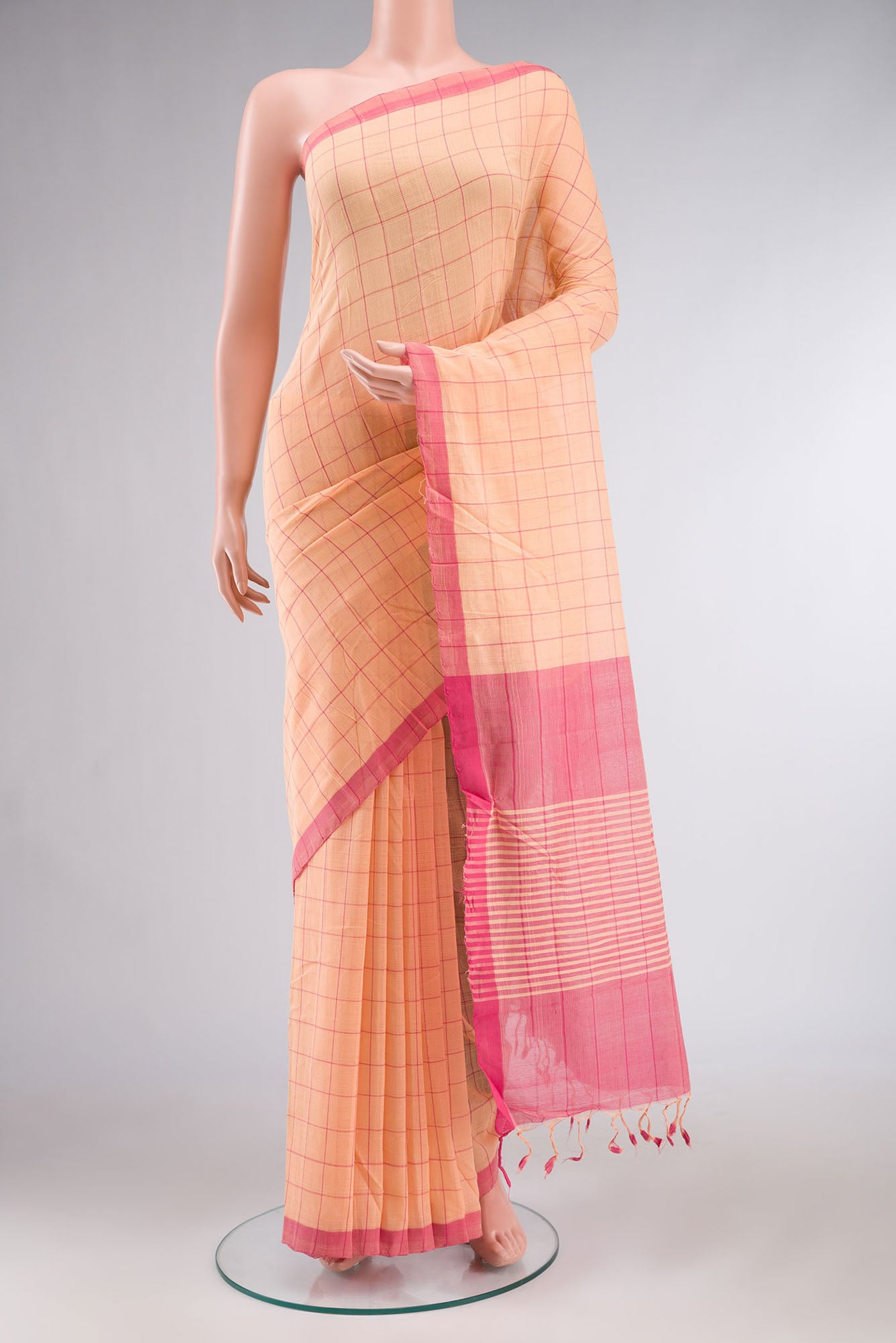 Peach Mangalagiri Cotton Saree with Checked design on the body and Plain Border.  displayed on a mannequin