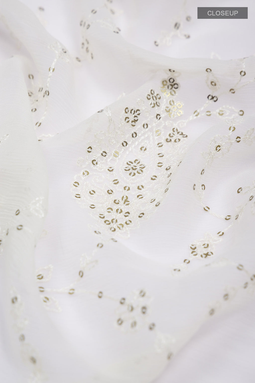 Close up of Cream Blended Chiffon Saree with Embroidery on the body and Lace Border.  displaying folds