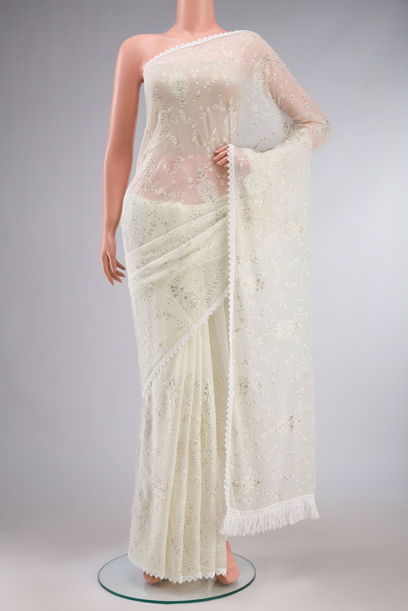 Cream Blended Chiffon Saree with Embroidery on the body and Lace Border.  displayed on a mannequin