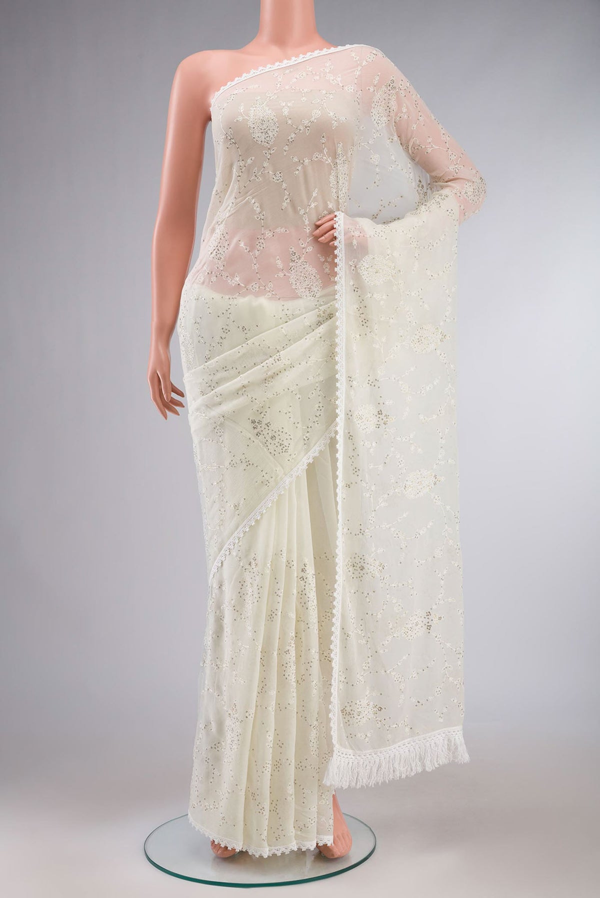 Cream Blended Chiffon Saree with Embroidery on the body and Lace Border.  displayed on a mannequin
