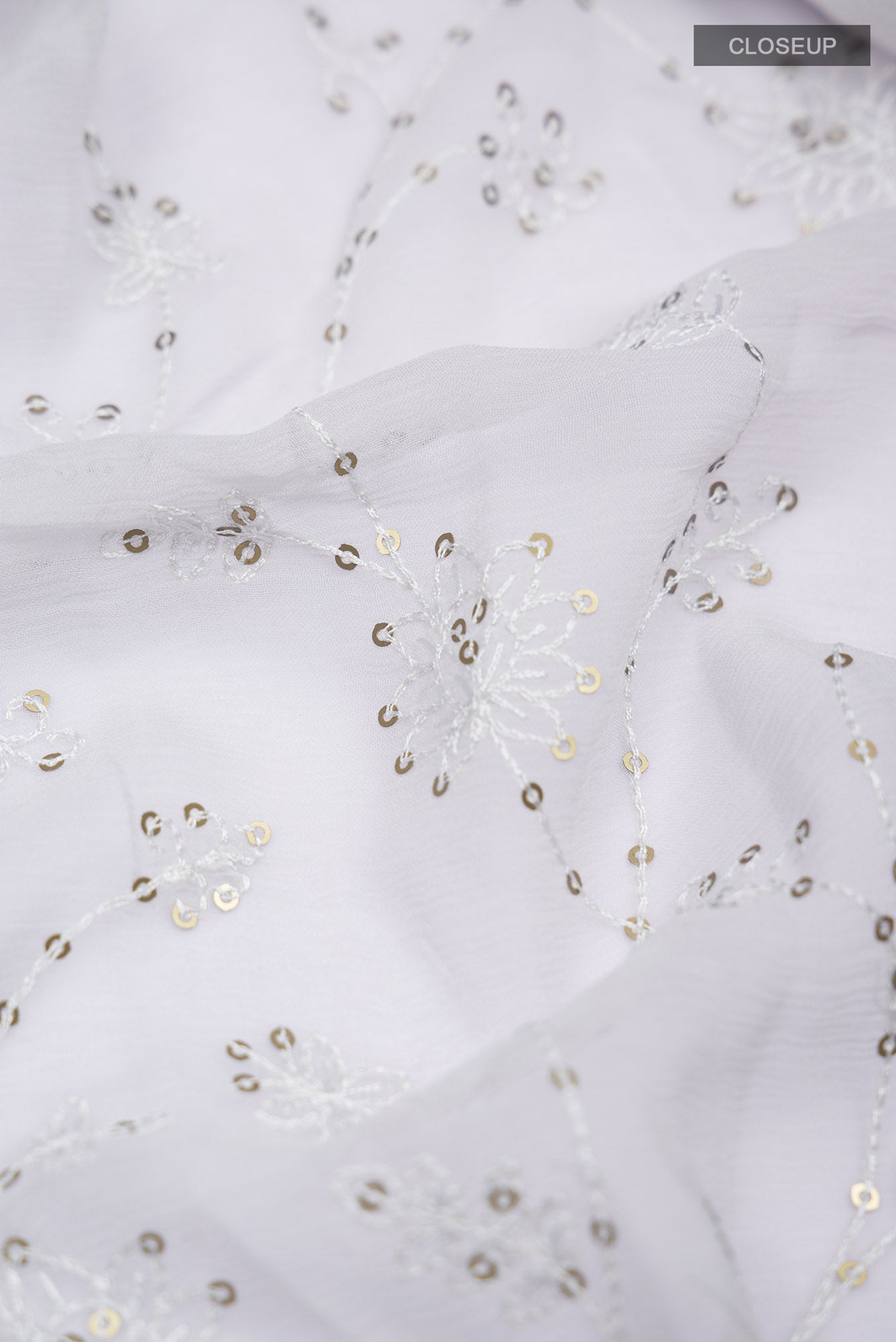 Close up of Grey Blended Chiffon Saree with Embroidery on the body and Lace Border.  displaying folds