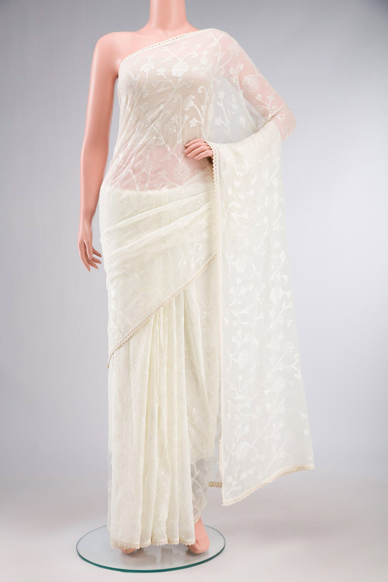 Cream Blended Chiffon Saree with Embroidery on the body and Lace Border.  displayed on a mannequin
