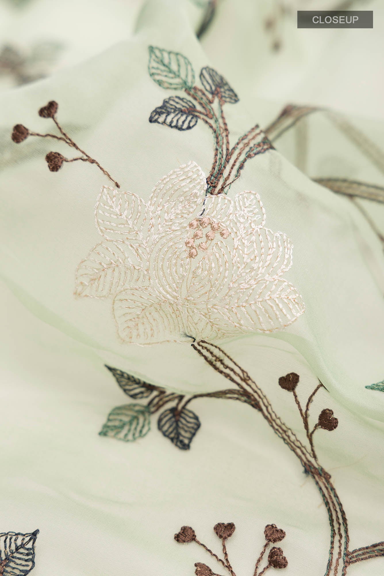 Close up of Green Blended Organza Silk Saree with Embroidery on the body and Zari Border.  displaying folds