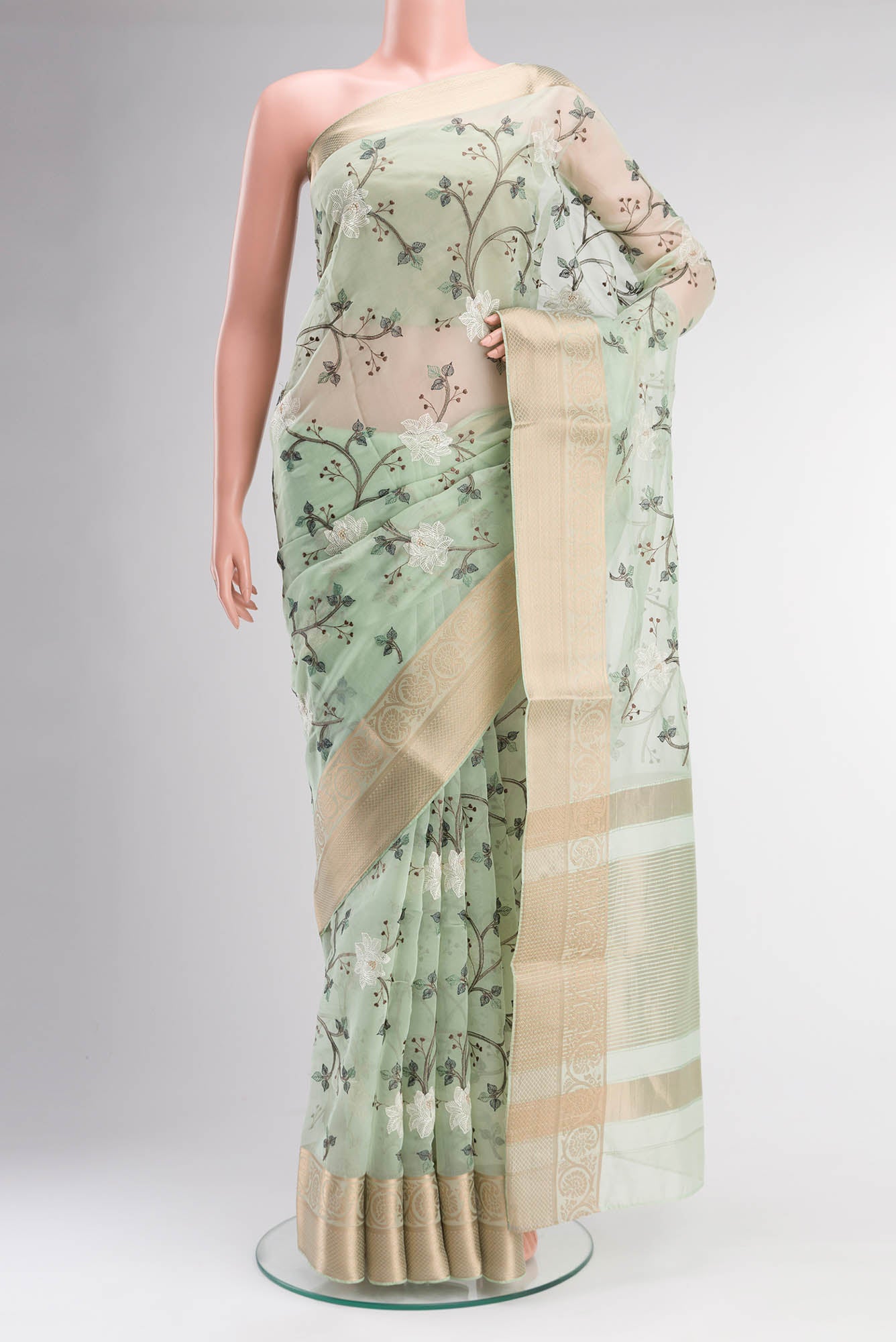 Green Blended Organza Silk Saree with Embroidery on the body and Zari Border.  displayed on a mannequin