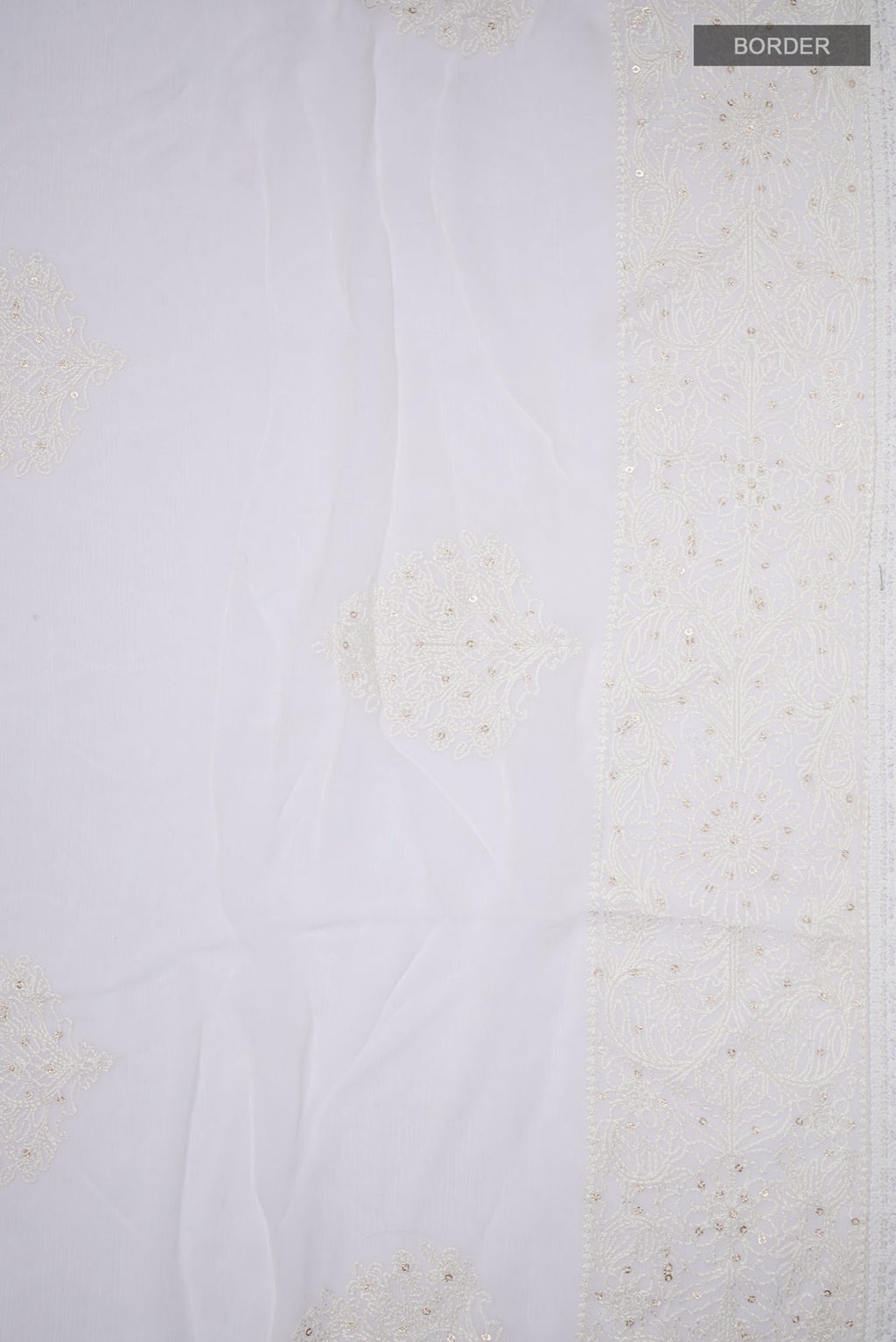 Border image of White Blended Chiffon Saree with Embroidery on the body and Embroidery Border. 
