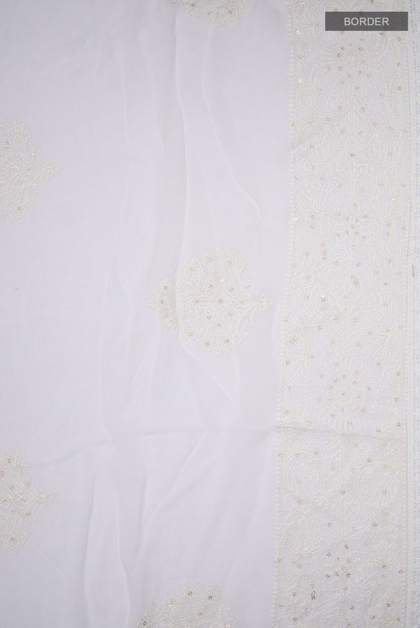Border image of White Blended Chiffon Saree with Embroidery on the body and Embroidery Border. 