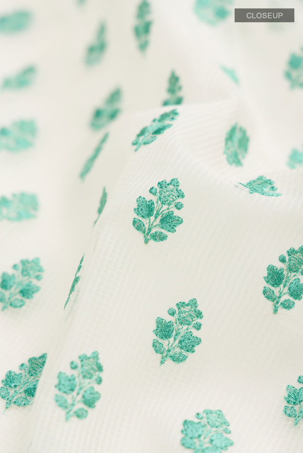 Close up of Cream Blended Kota Cotton Saree with Embroidery on the body and Thread Border.  displaying folds