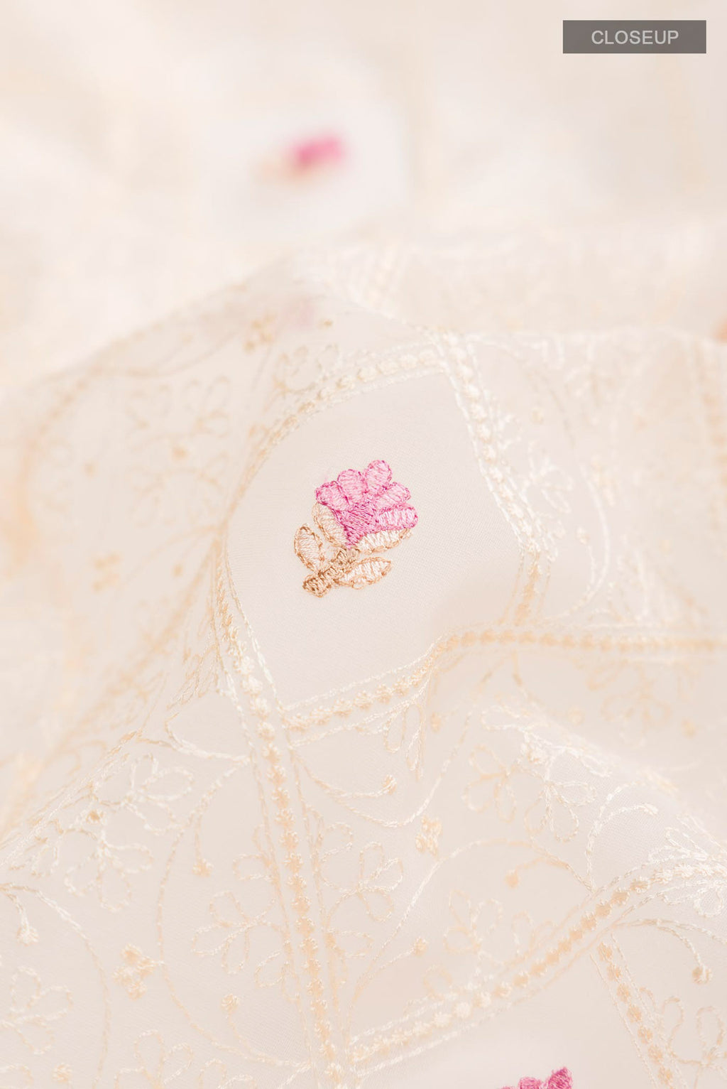 Close up of Cream Blended Kora Cotton Saree with Embroidery on the body and Zari Border.  displaying folds