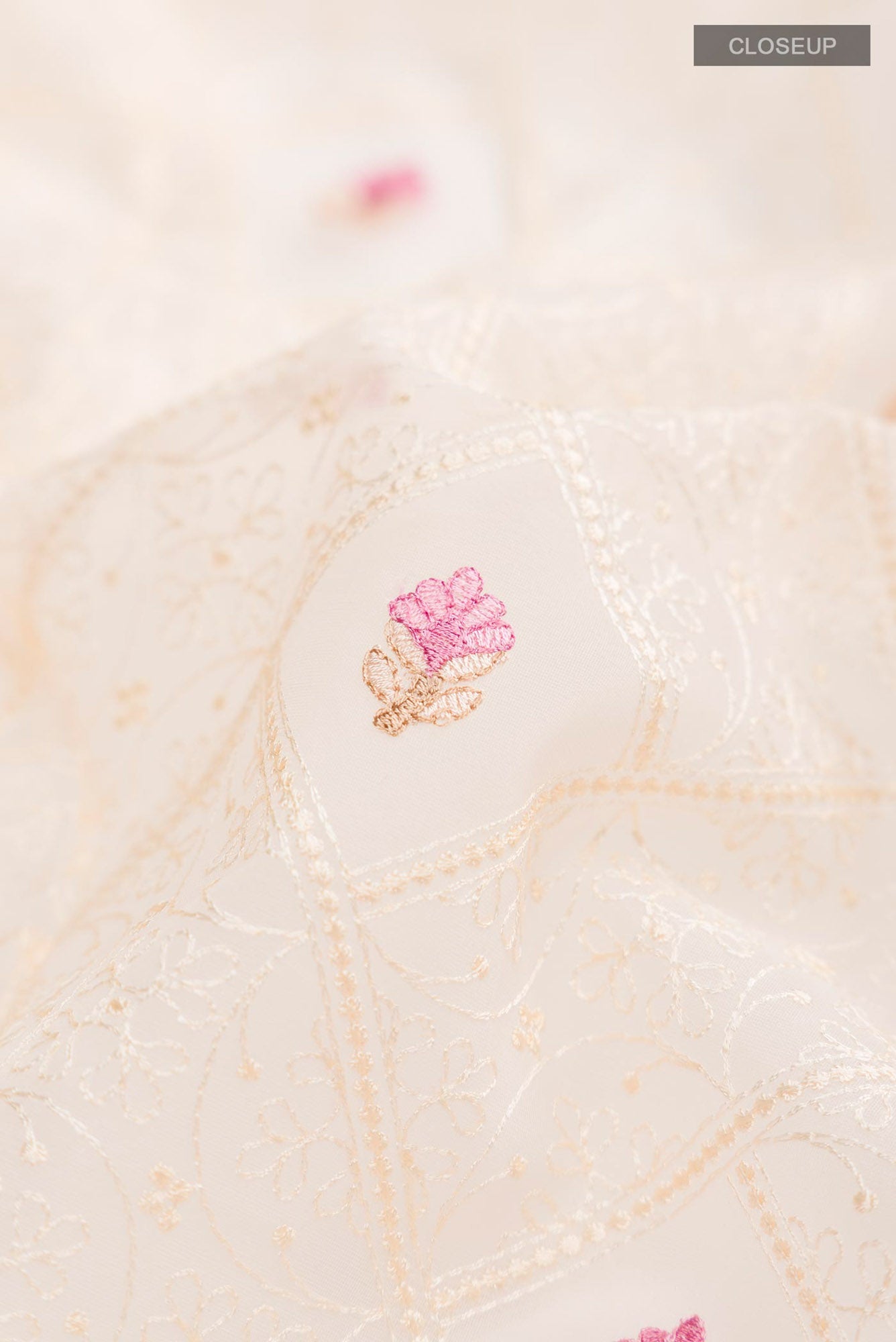 Close up of Cream Blended Kora Cotton Saree with Embroidery on the body and Zari Border.  displaying folds