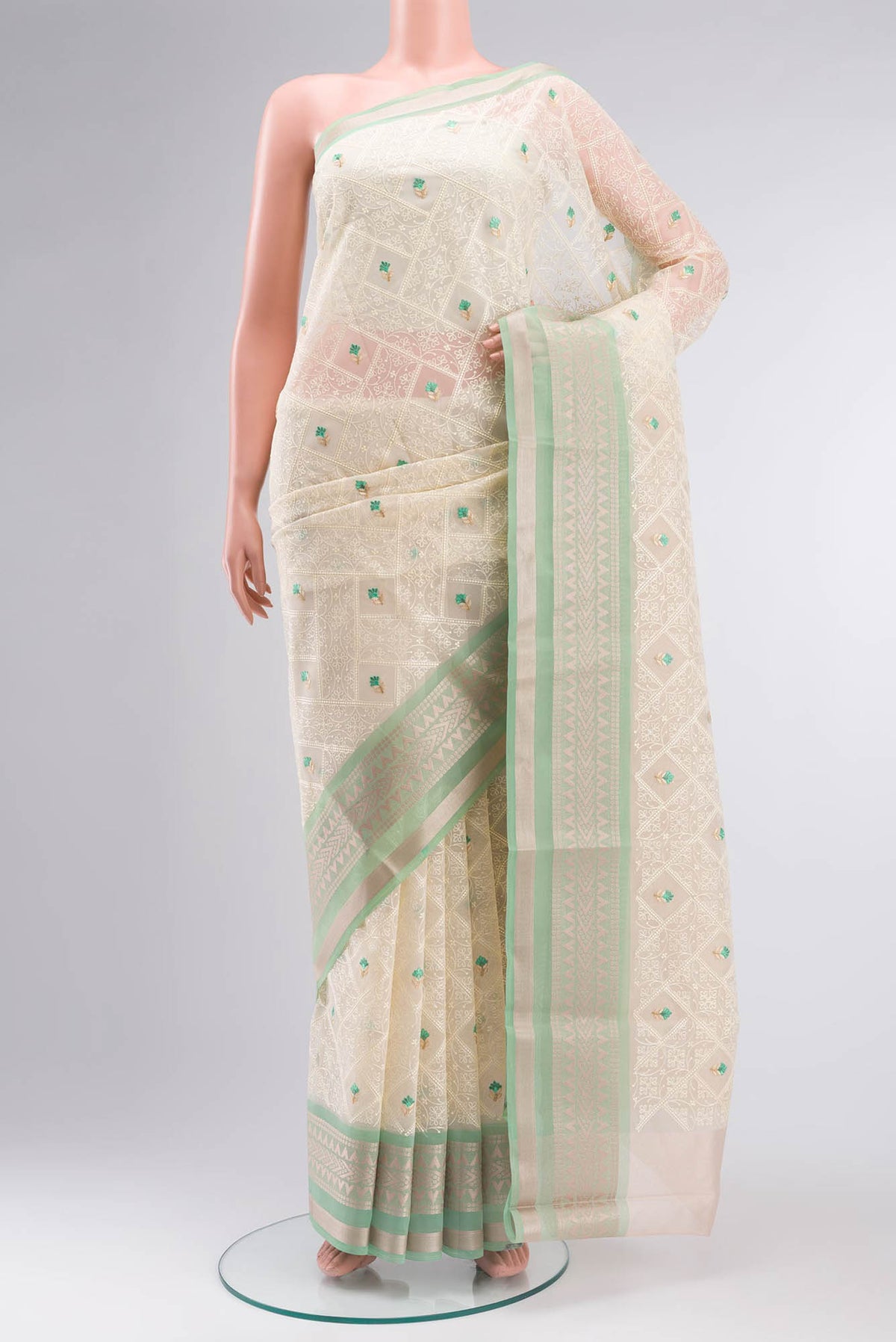 Cream Blended Kora Cotton Saree with Embroidery on the body and Zari Border.  displayed on a mannequin