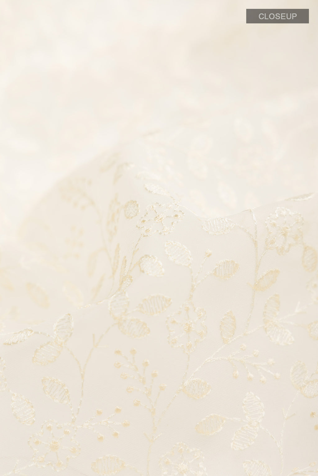 Close up of Cream Blended Kora Cotton Saree with Embroidery on the body and Zari And Thread Border.  displaying folds