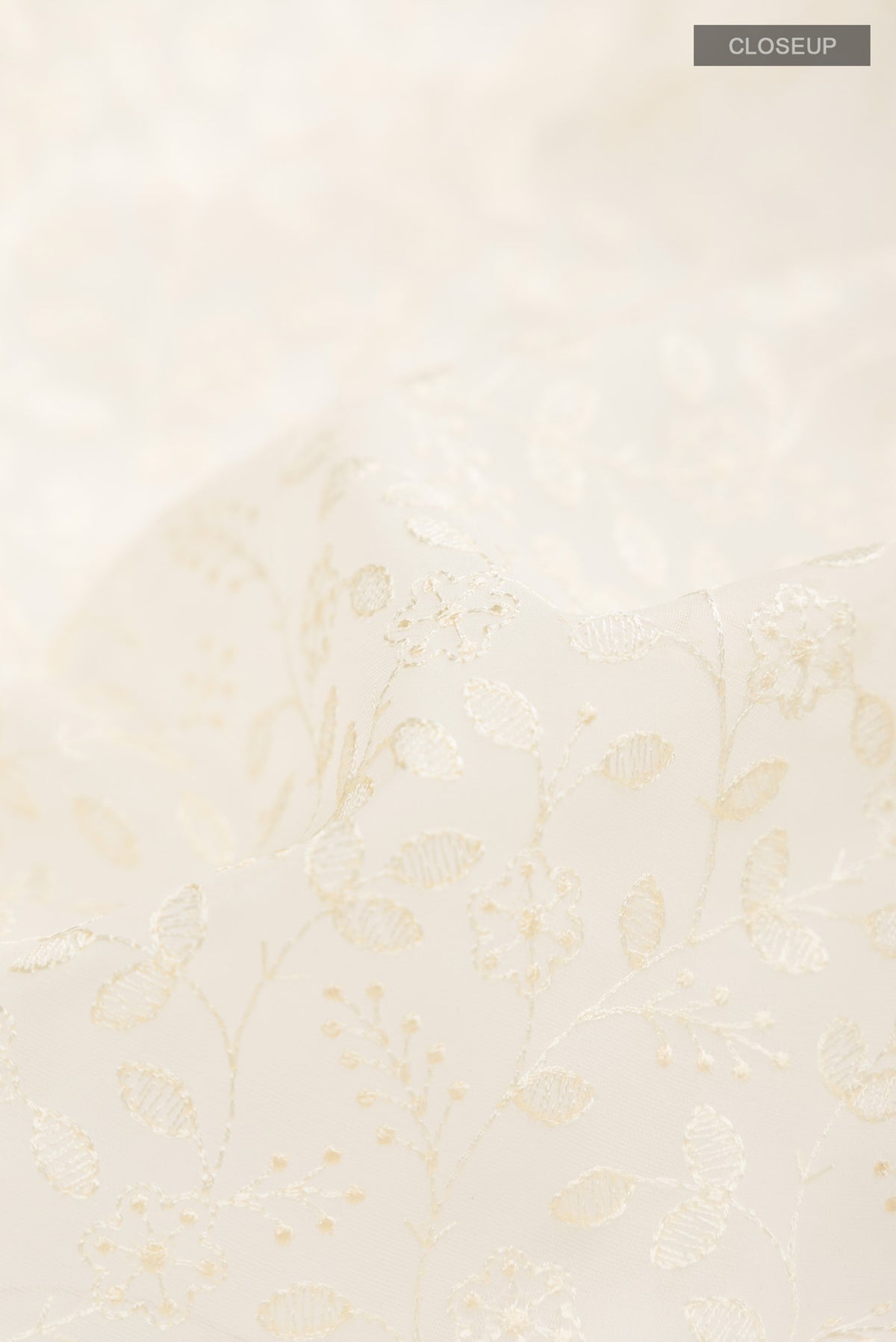 Close up of Cream Blended Kora Cotton Saree with Embroidery on the body and Zari And Thread Border.  displaying folds