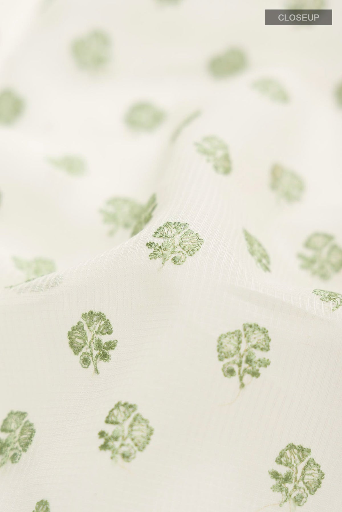 Close up of Cream Blended Kota Cotton Saree with Embroidery on the body and Thread Border.  displaying folds