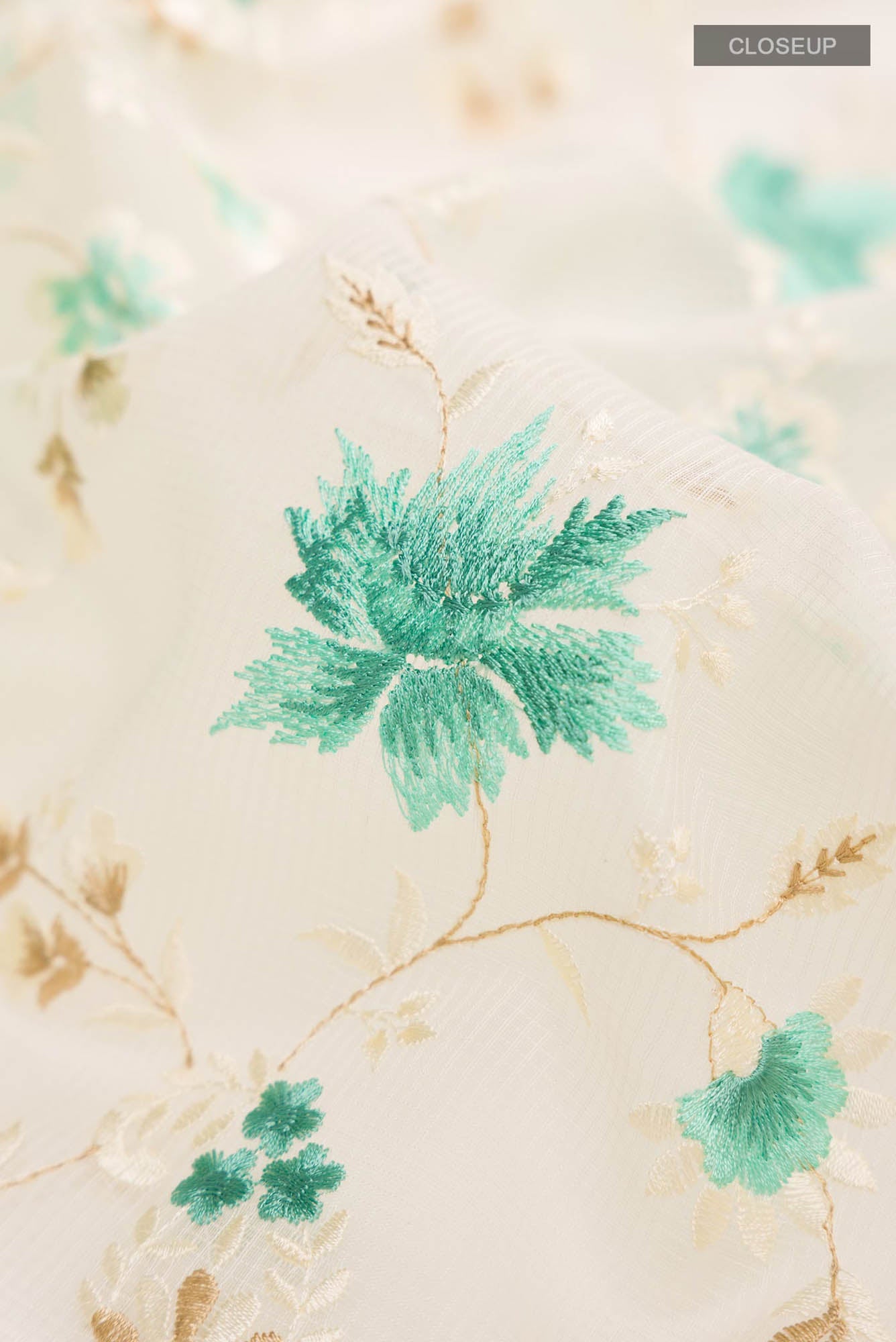 Close up of Cream Blended Kota Cotton Saree with Embroidery on the body and Thread Border.  displaying folds