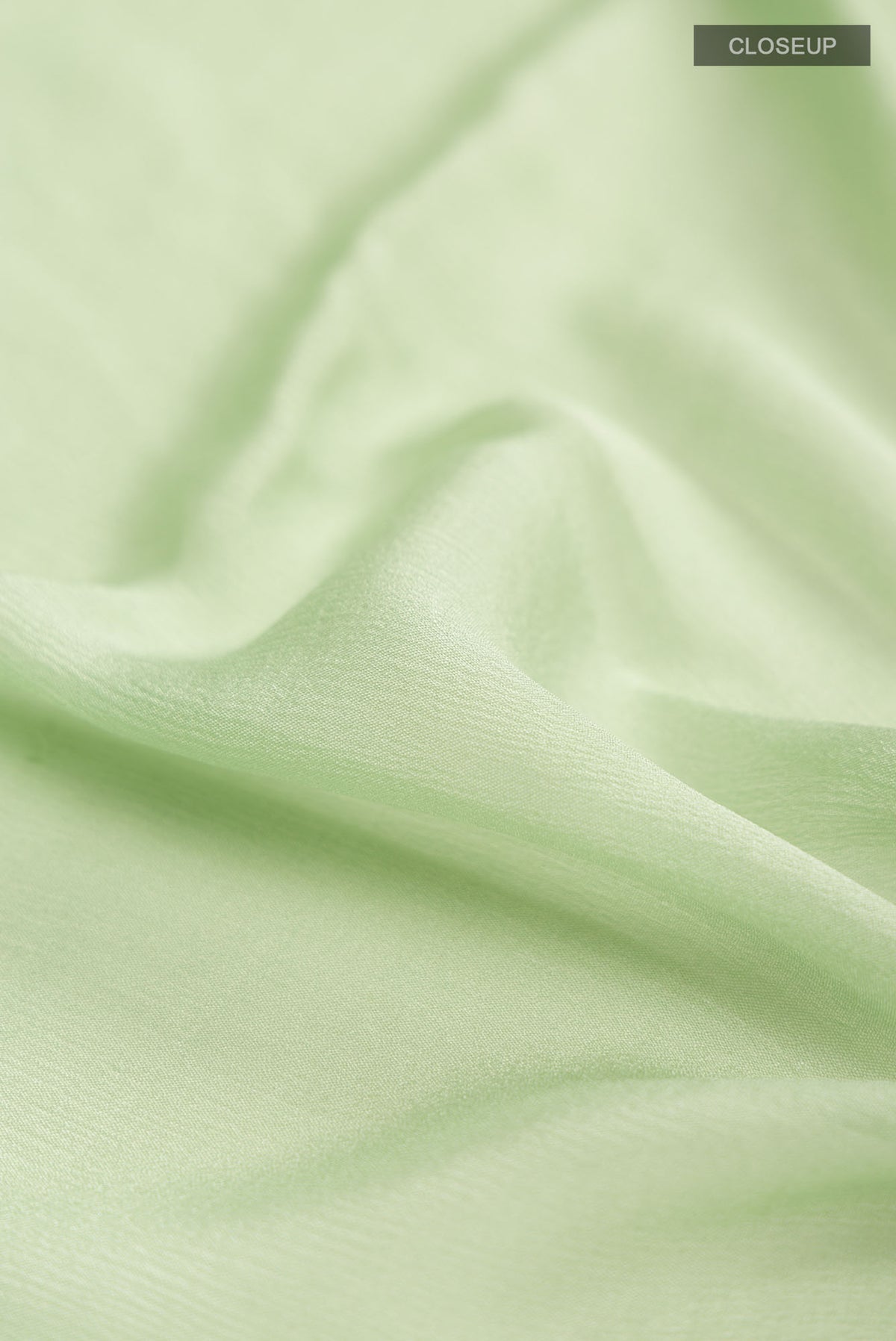 Close up of Green Mysore Chiffon Saree with Plain Body and Zari Border.  displaying folds