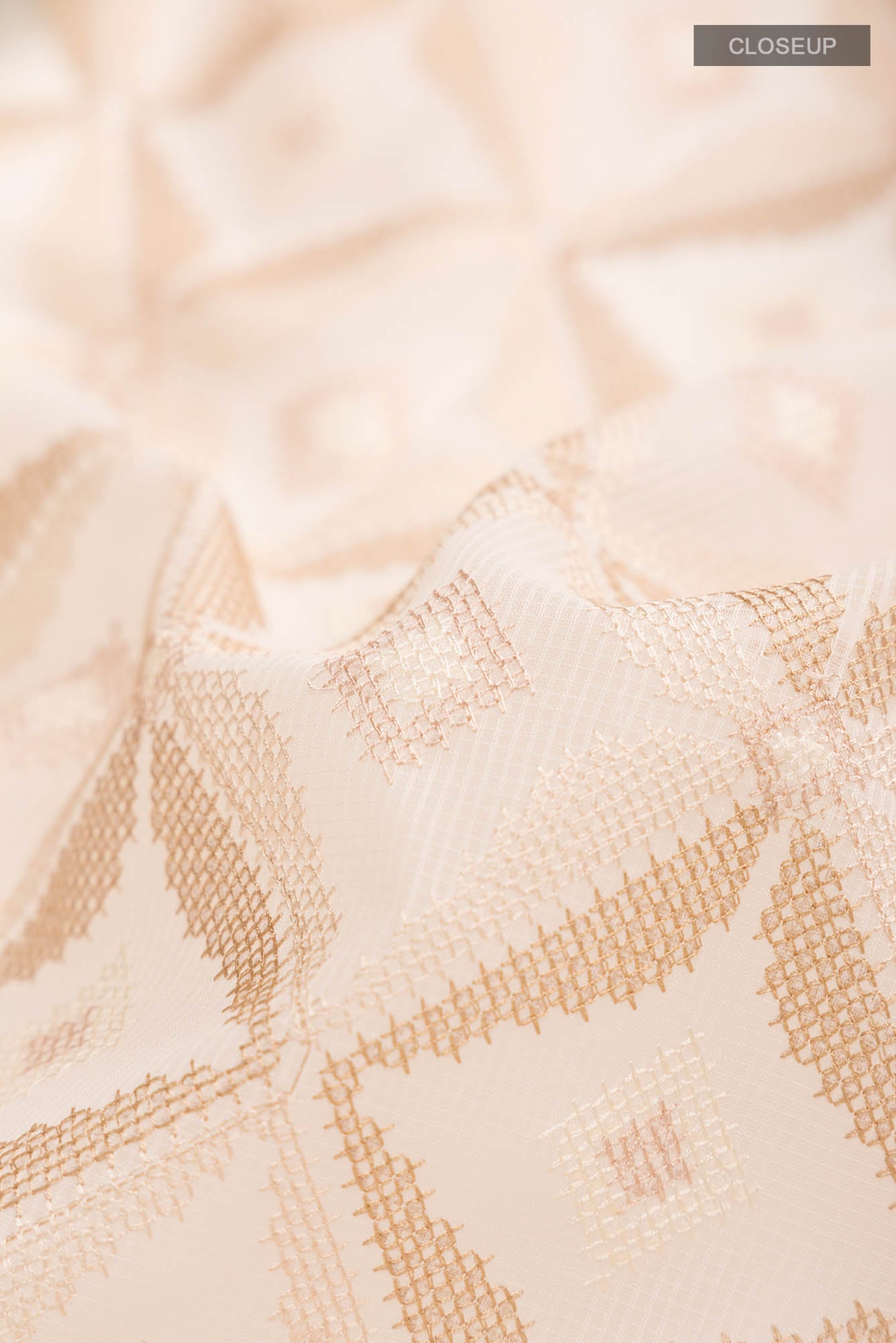 Close up of Cream Blended Kota Cotton Saree with Embroidery on the body and Thread Border.  displaying folds