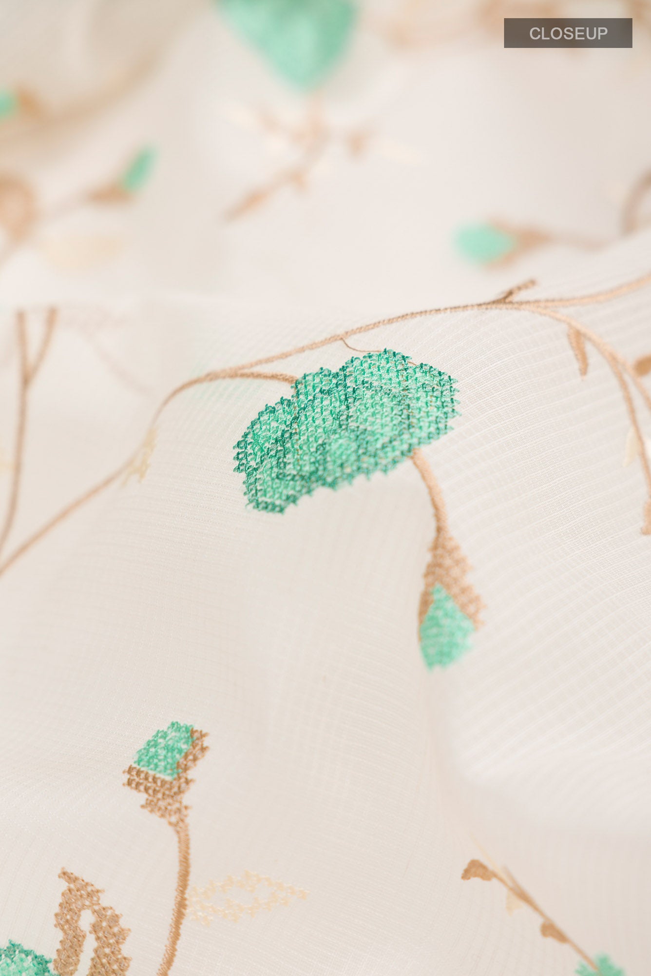 Close up of Cream Blended Kota Cotton Saree with Embroidery on the body and Thread Border.  displaying folds