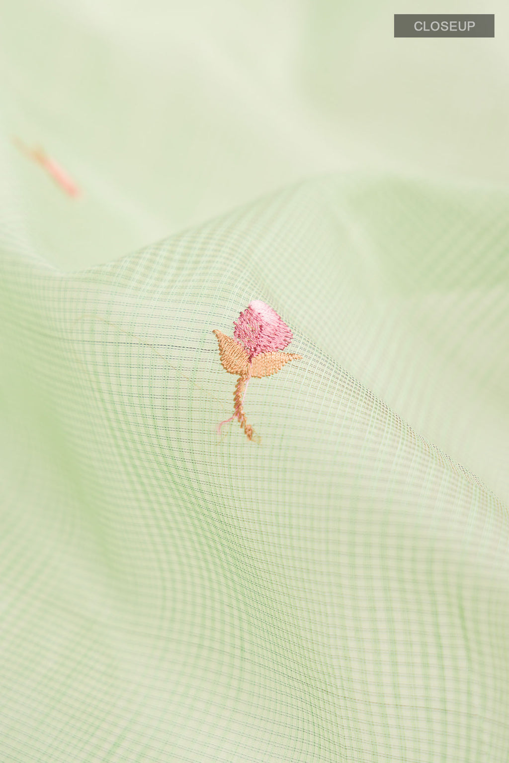 Close up of Green Blended Kota Cotton Saree with Embroidery on the body and Zari Border.  displaying folds