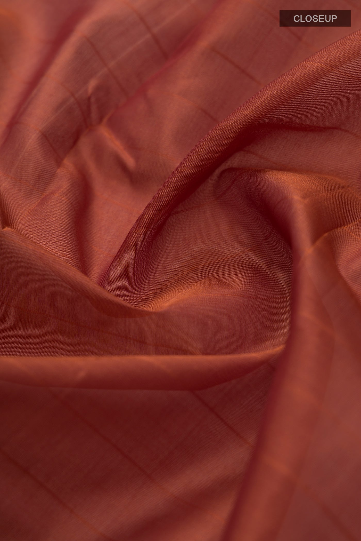 Close up of Orange Kanchipuram Silk Saree with Stripes on the body and Zari Border.  displaying folds