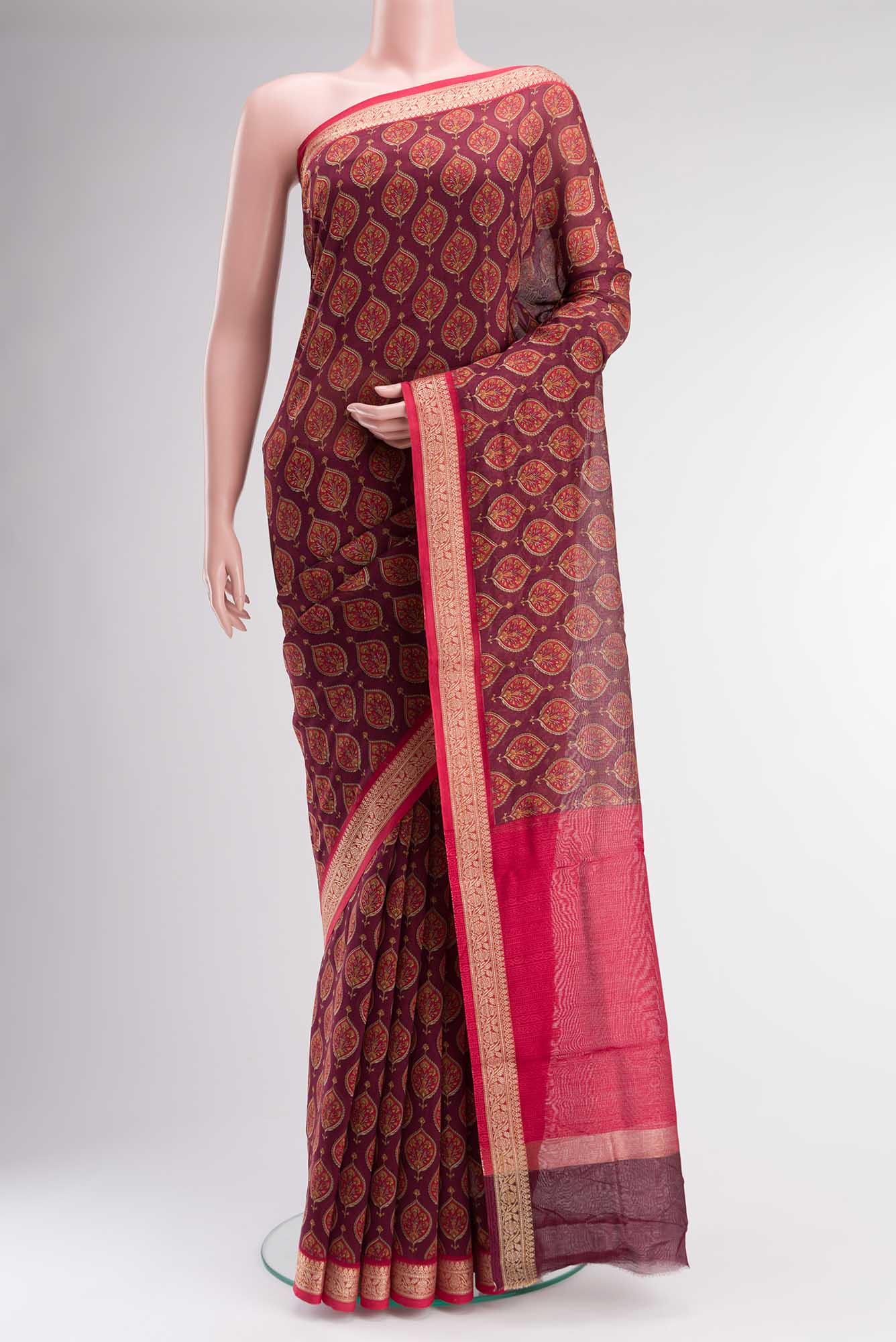 Maroon Silk Cotton Saree with Floral Print on the body and Zari Border.  displayed on a mannequin