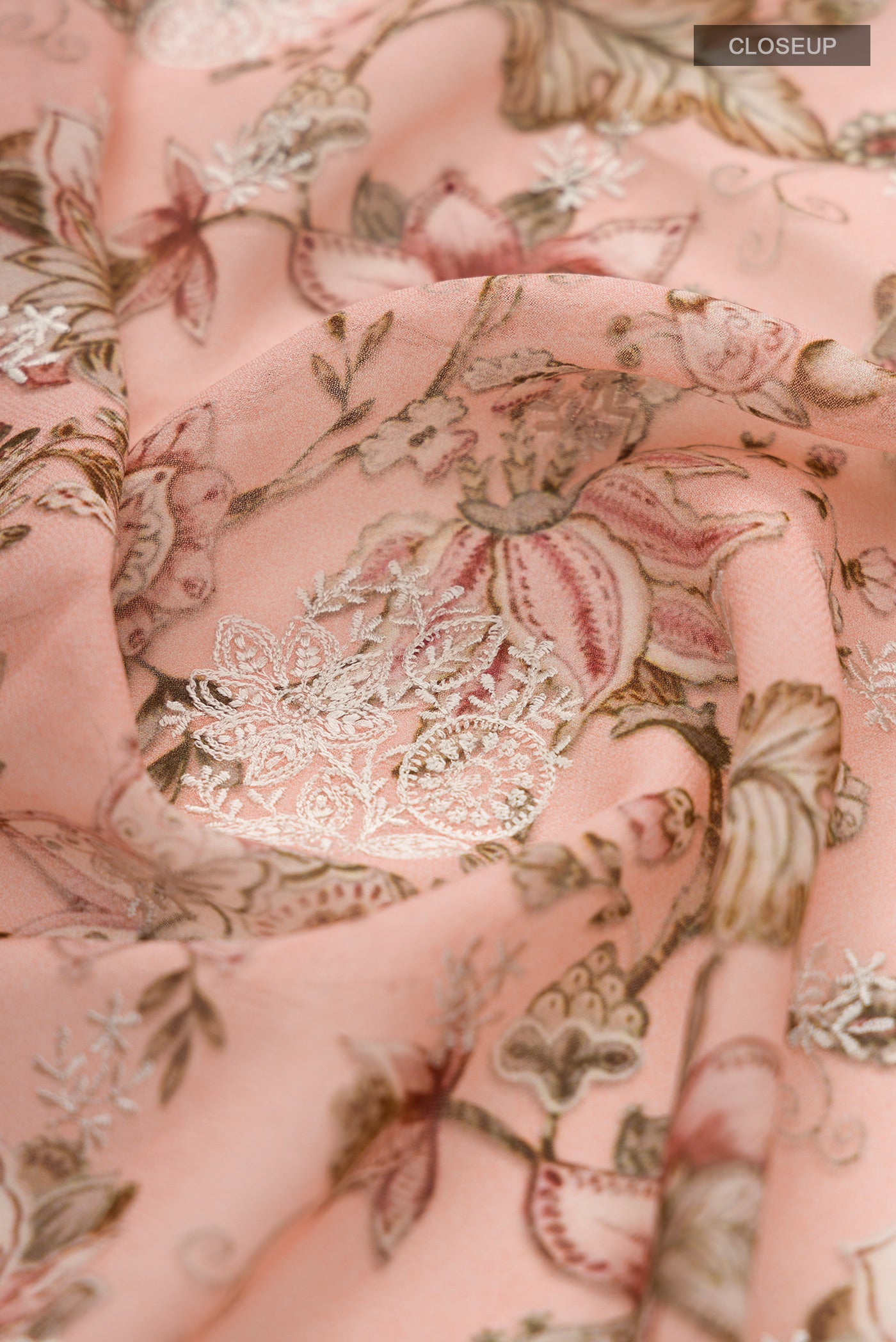 Close up of Peach Georgette Saree with Floral Print on the body and Embroidery Border.  displaying folds