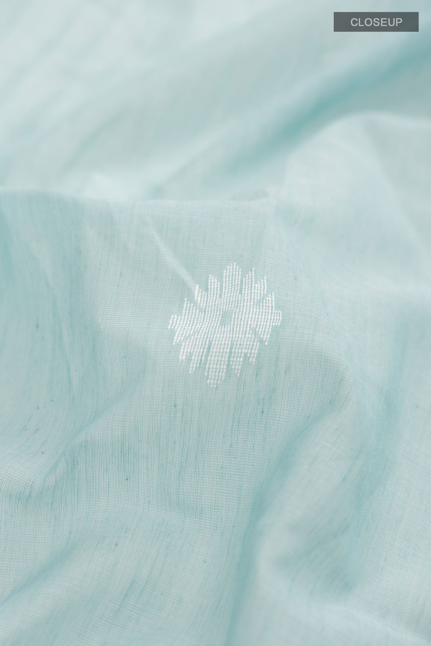 Close up of Sea Green Bengal Cotton Saree with Thread Butta on the body and Zari Border displaying folds