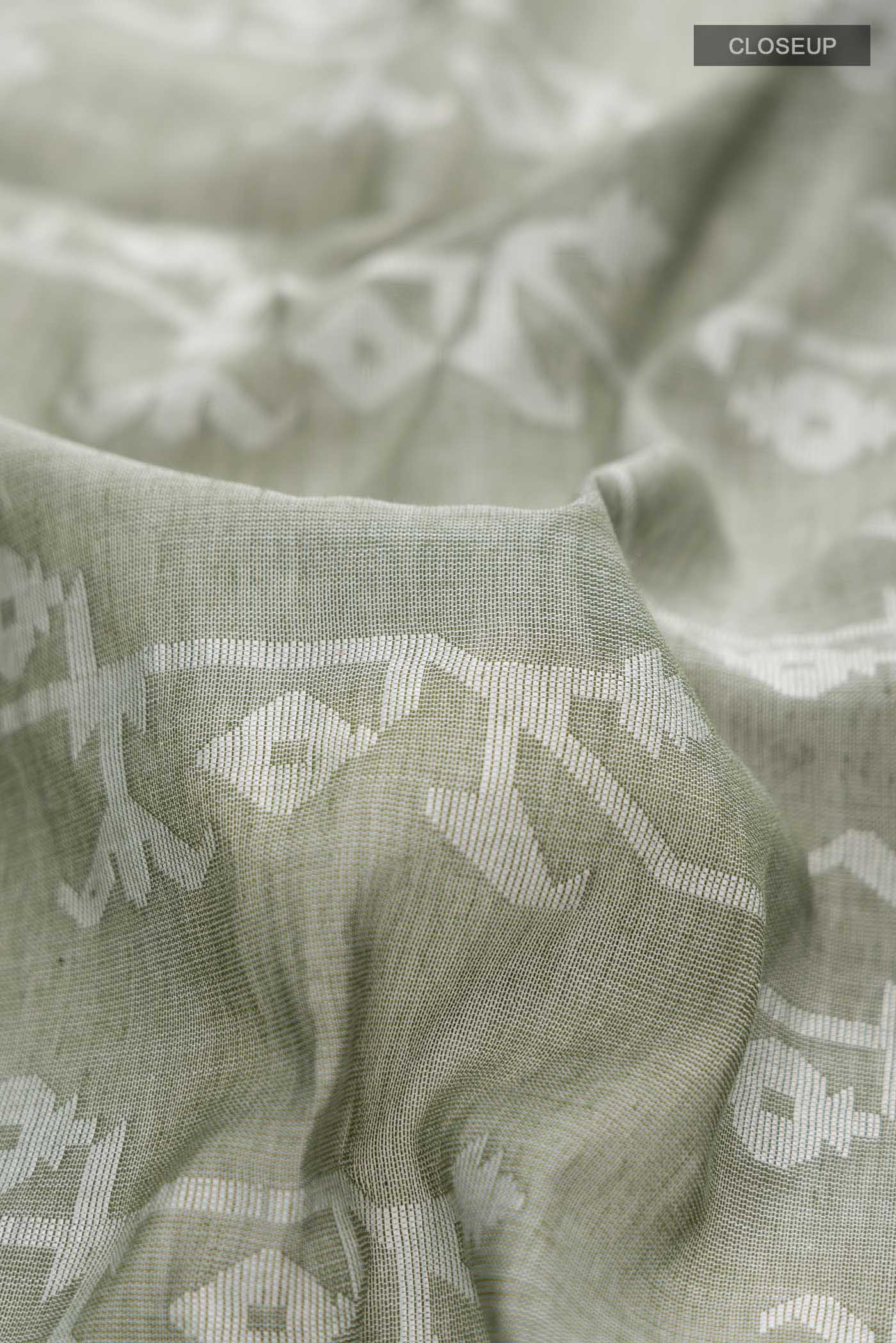 Close up of Olive Green Bengal Cotton Saree with Jamdani on the body and Zari Border displaying folds