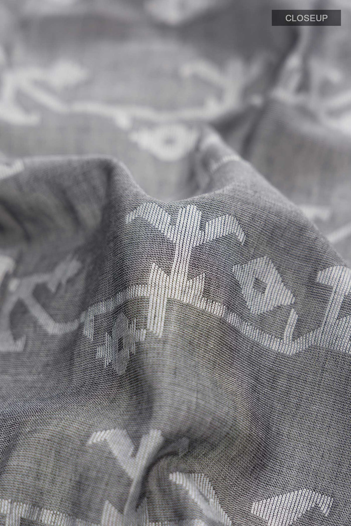 Close up of Grey Bengal Cotton Saree with Jamdani on the body and Zari Border displaying folds