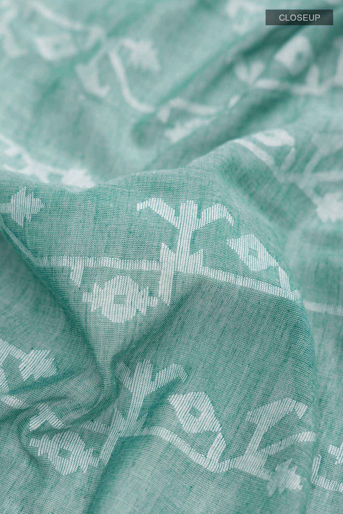 Close up of Green Bengal Cotton Saree with Jamdani on the body and Zari Border displaying folds