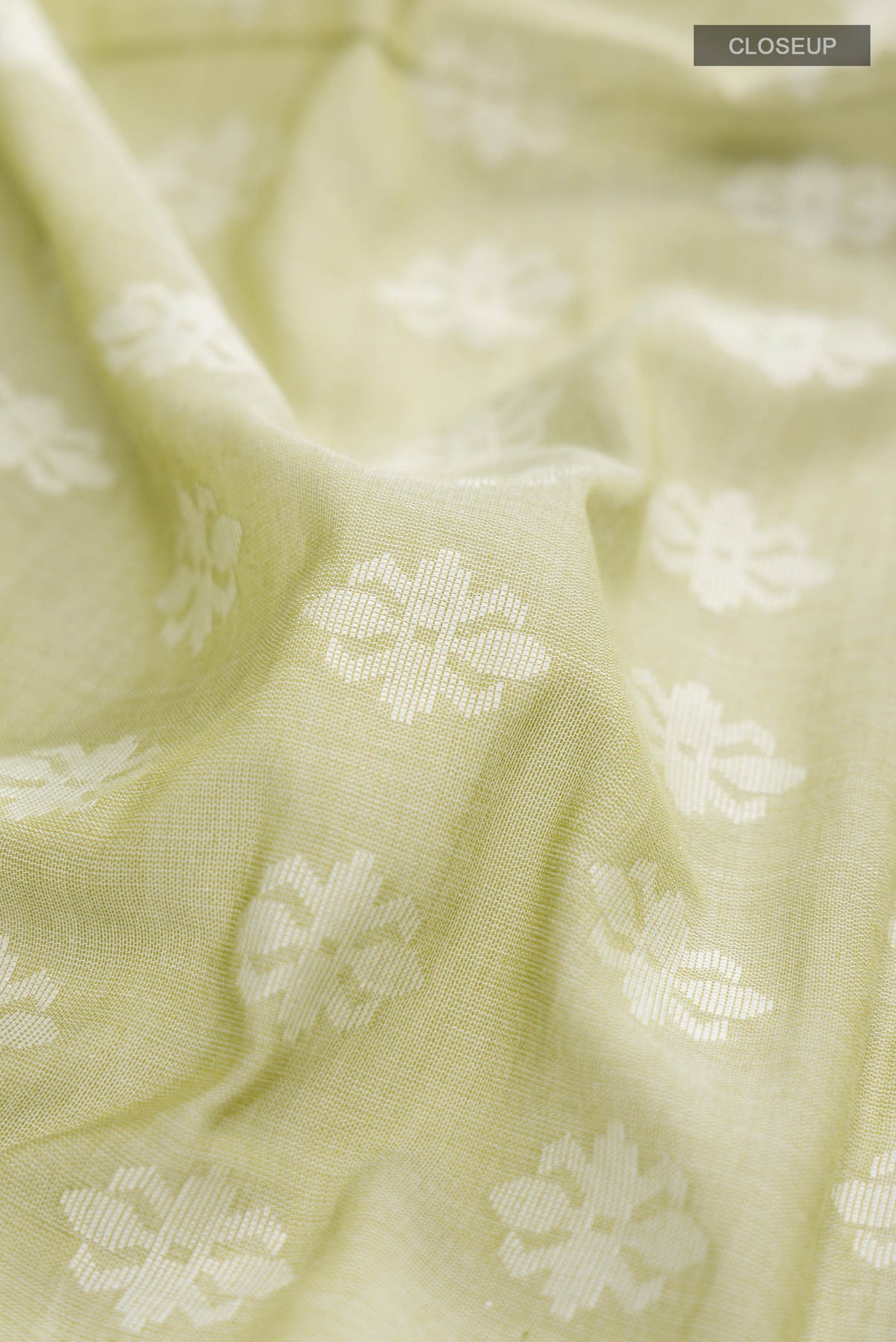 Close up of Light Green Bengal Cotton Saree with Jamdani on the body and Thread Border displaying folds