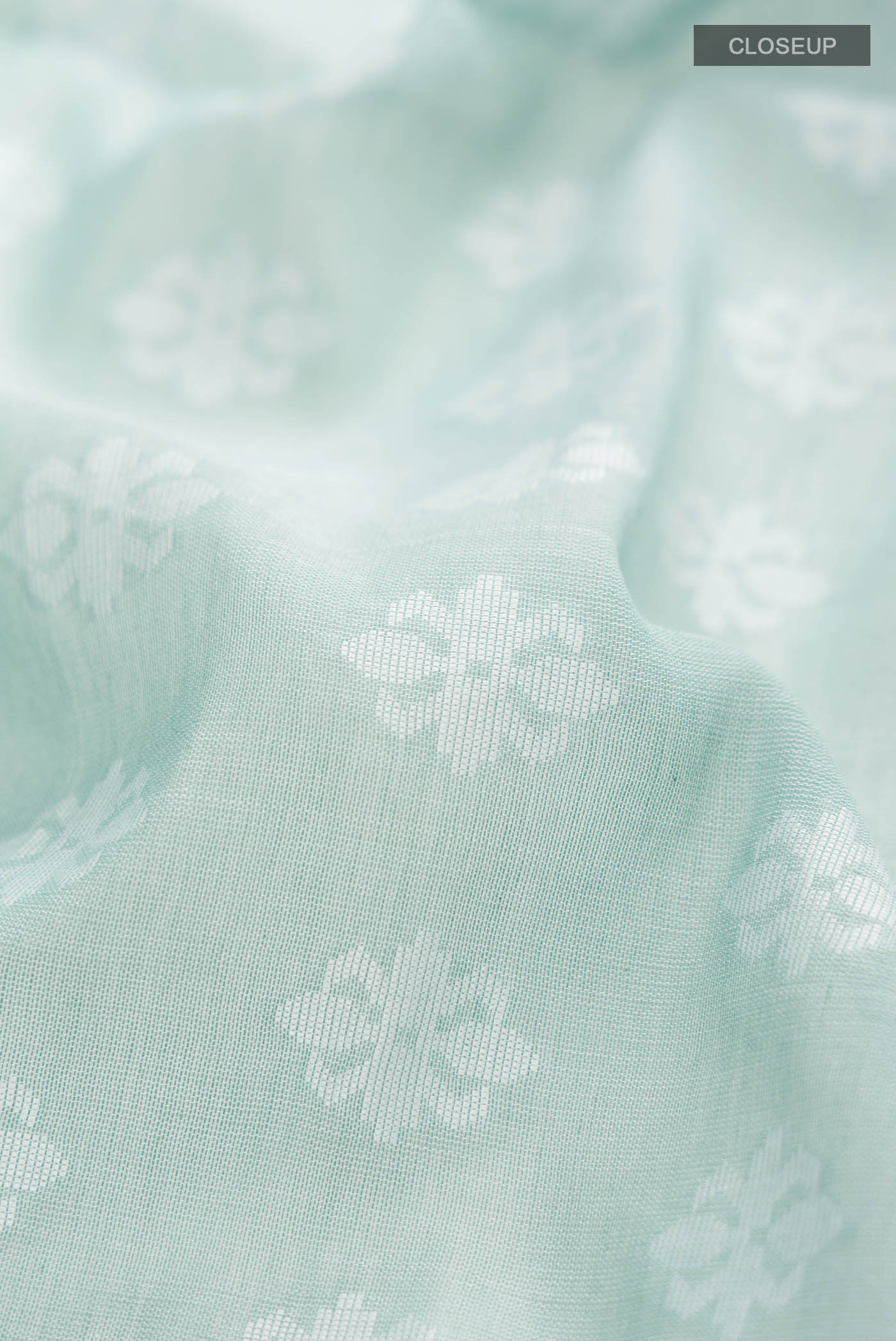 Close up of Light Green Bengal Cotton Saree with Jamdani on the body and Thread Border displaying folds