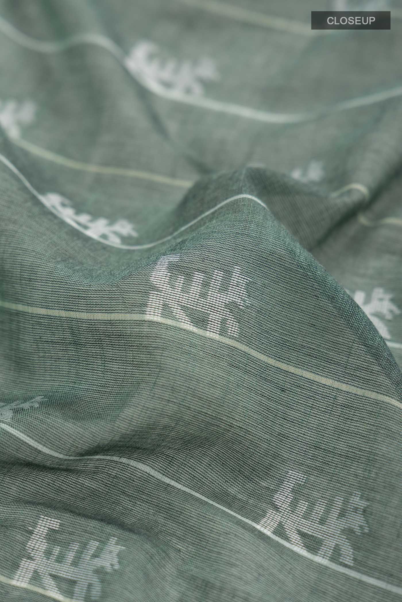 Close up of Green Bengal Cotton Saree with Jamdani on the body and Thread Border displaying folds
