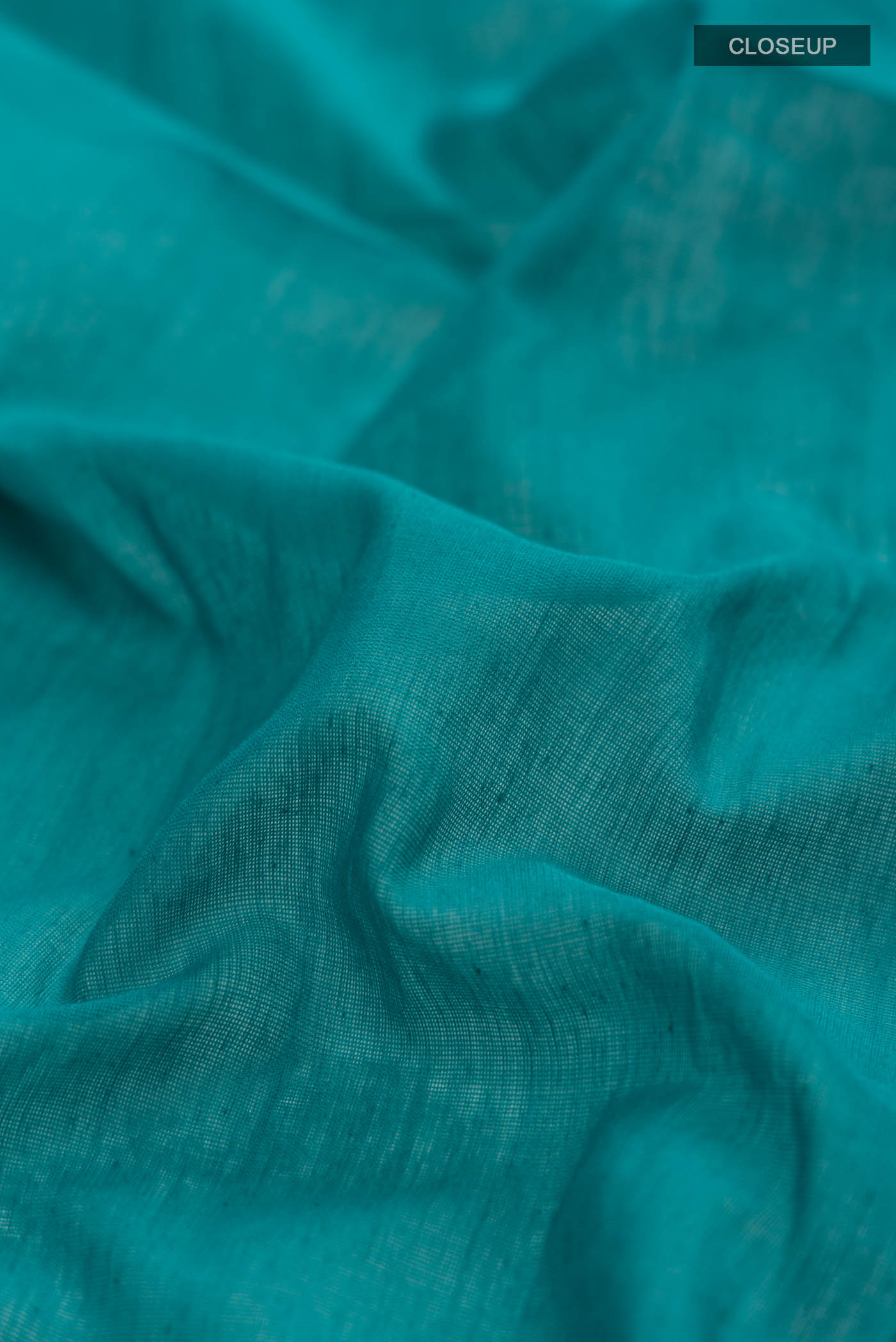 Close up of Teal Bengal Cotton Saree with Plain Body and Zari Border displaying folds