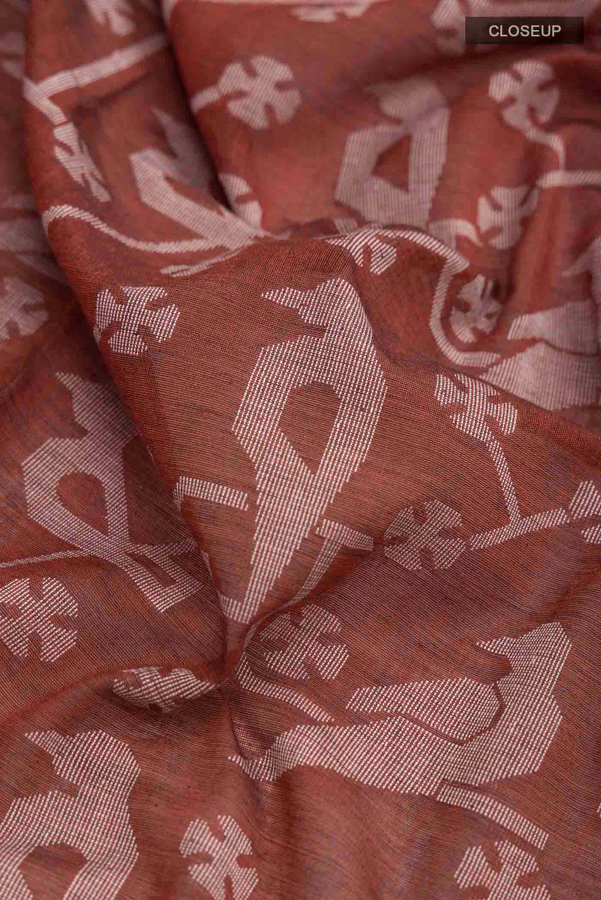 Close up of Rust Bengal Cotton Saree with Jamdani on the body and Thread Border displaying folds