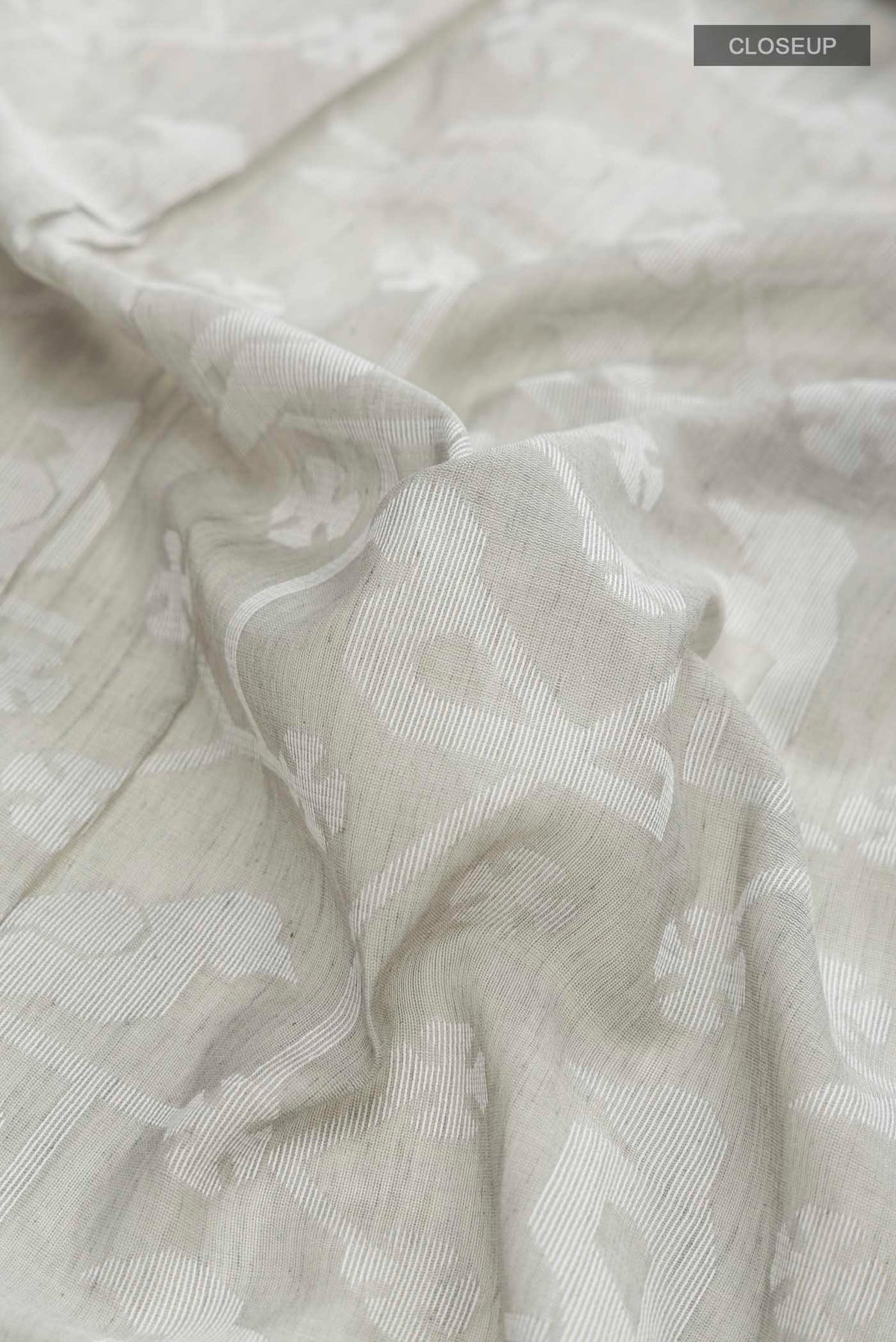 Close up of Grey Bengal Cotton Saree with Jamdani on the body and Thread Border displaying folds