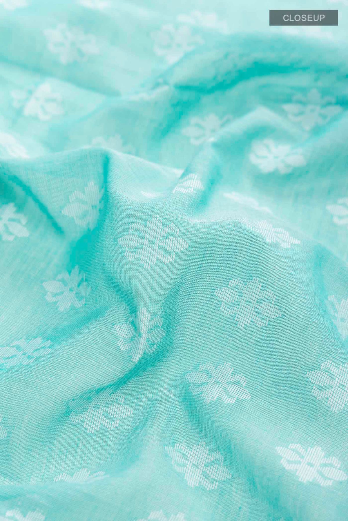 Close up of Sea Green Bengal Cotton Saree with Jamdani on the body and Thread Border displaying folds
