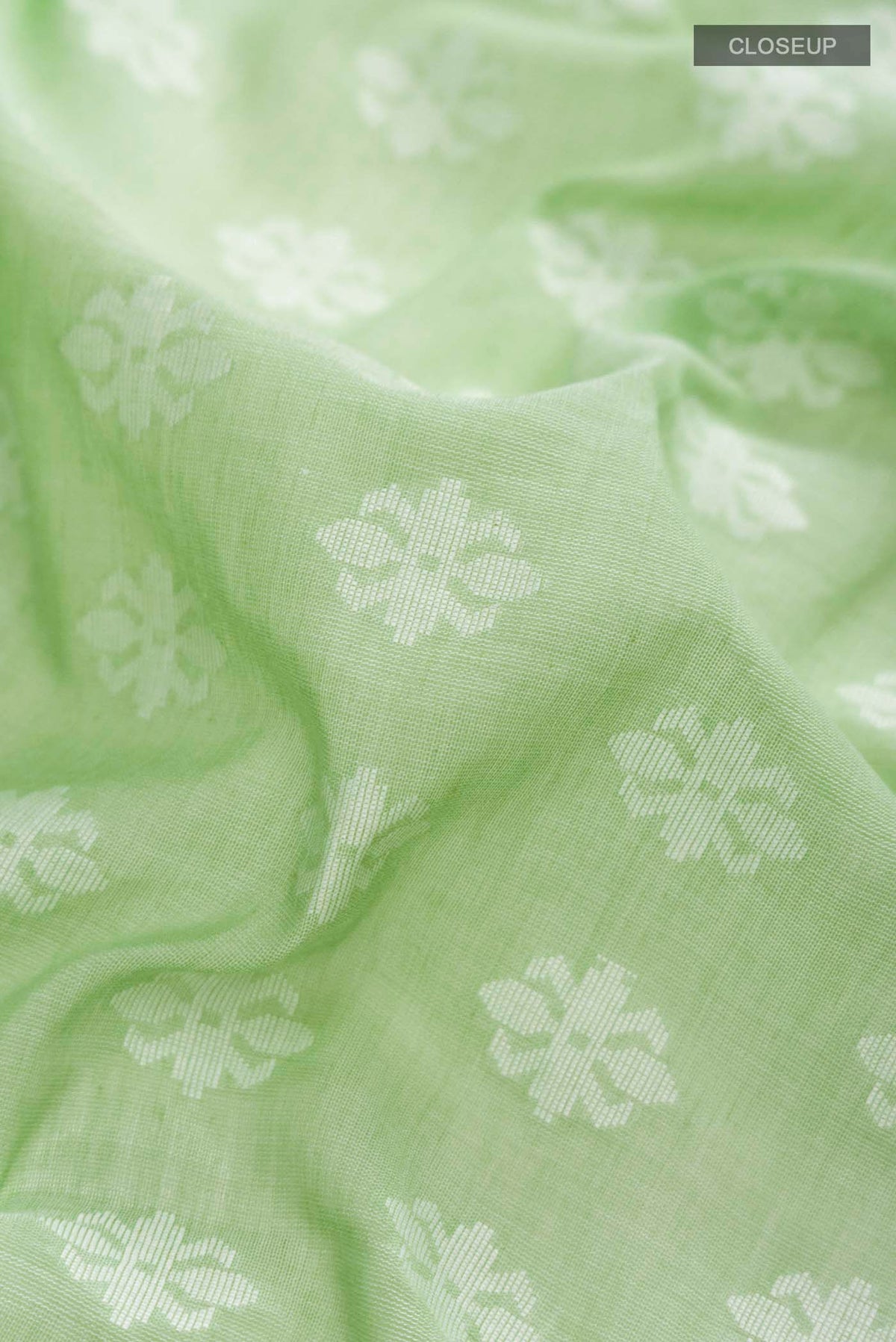 Close up of Pista Green Bengal Cotton Saree with Jamdani on the body and Thread Border displaying folds