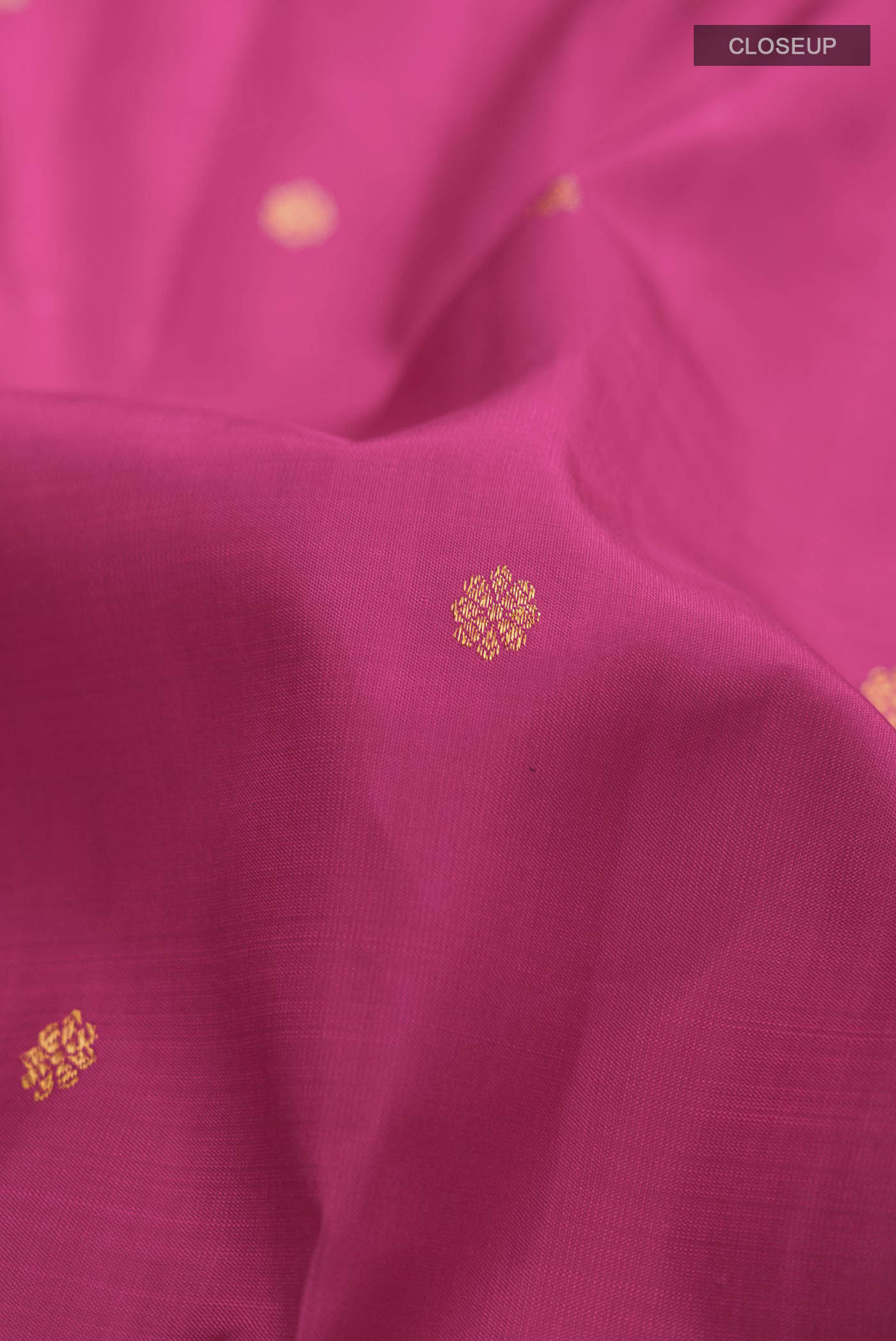 Close up of Pink Kanchipuram Silk Saree with Zari Butta on the body and Zari Border displaying folds