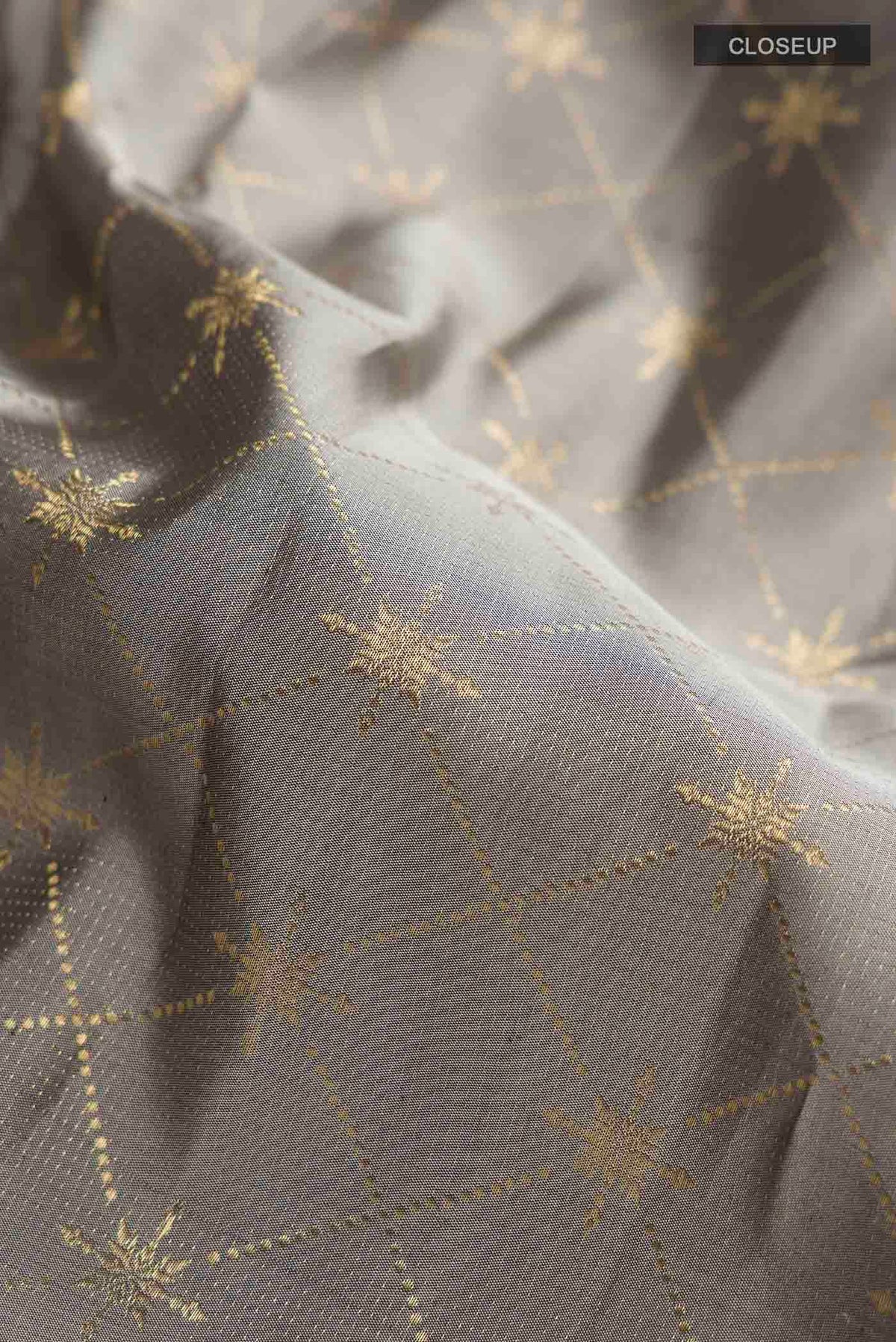 Close up of Grey Kanchipuram Silk Saree with Zari Butta on the body and Zari Border displaying folds