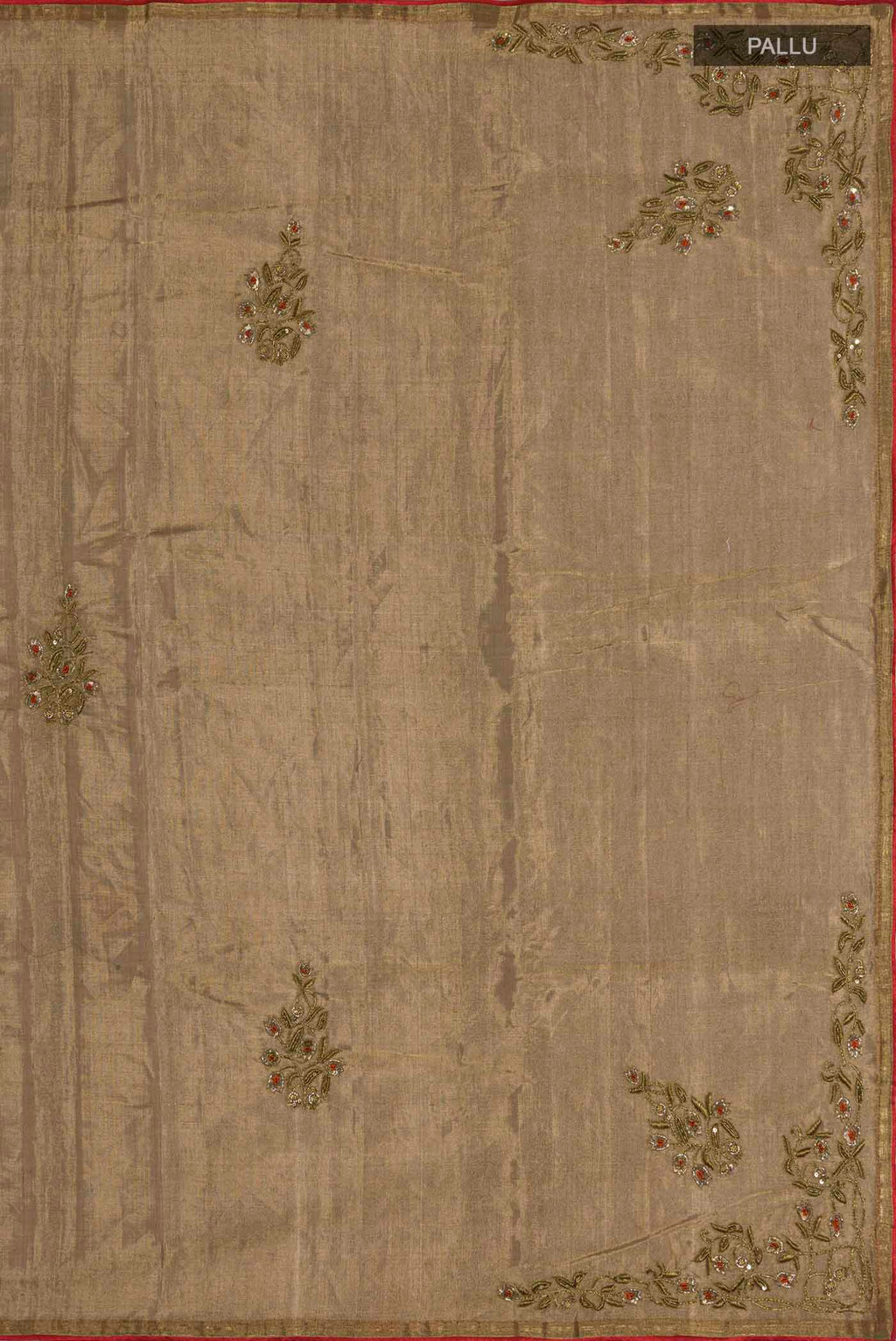 Close up image of the pallu of Rumana is crafted in delicate tissue enriched with antique-gold zardozi, brought to life through dabka, sequins, and coloured beads The pallu unfolds with konia motifs and flowing pomegranate vines, anchored by a drop-shaped buta rendered in a stylised pomegranate form The body carries evenly placed butas that continue into the pleats, lending the saree a gentle, composed rhythm A classic gota trim completes this elegant expression of symbolic craft