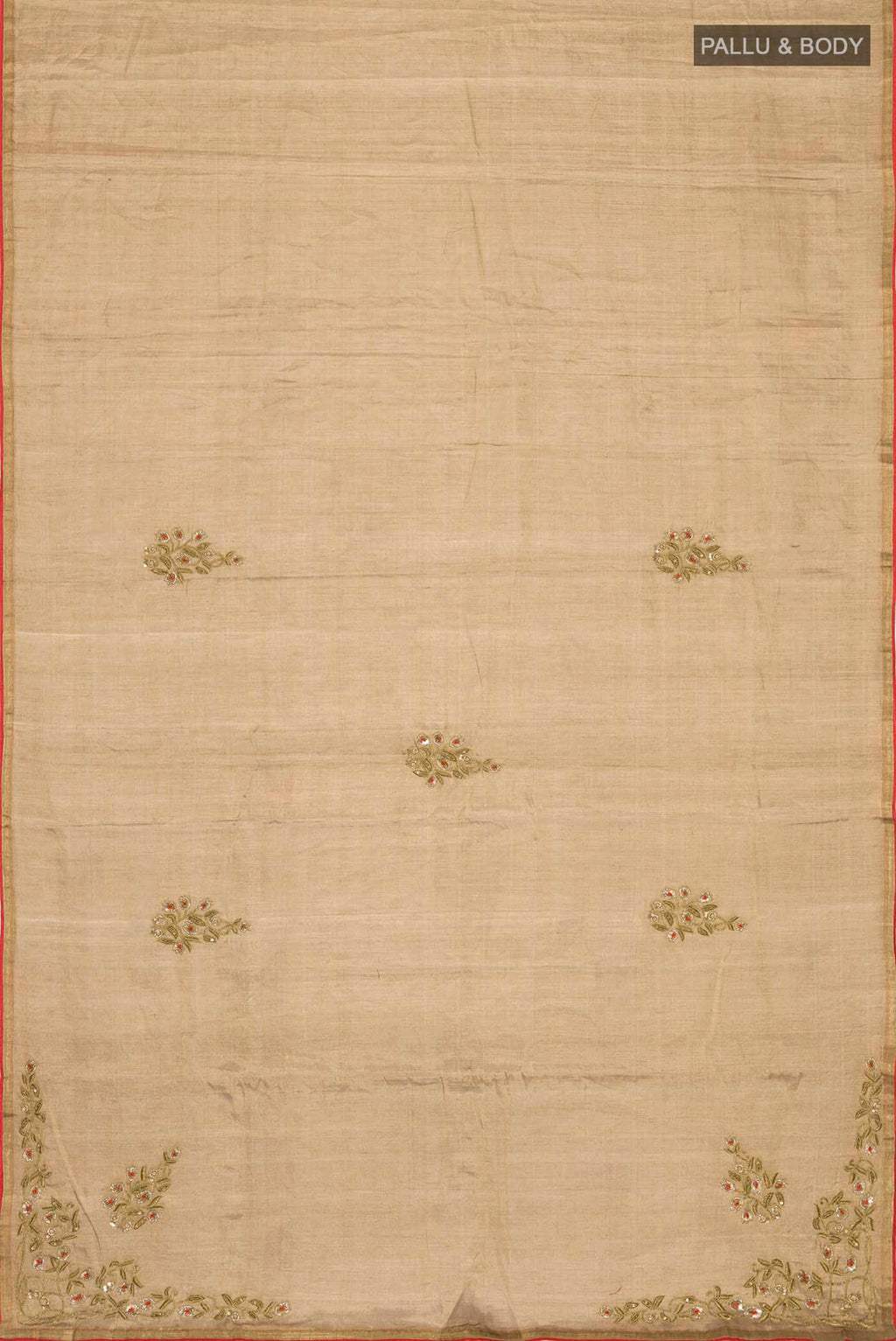 Flat view of Rumana is crafted in delicate tissue enriched with antique-gold zardozi, brought to life through dabka, sequins, and coloured beads The pallu unfolds with konia motifs and flowing pomegranate vines, anchored by a drop-shaped buta rendered in a stylised pomegranate form The body carries evenly placed butas that continue into the pleats, lending the saree a gentle, composed rhythm A classic gota trim completes this elegant expression of symbolic craft