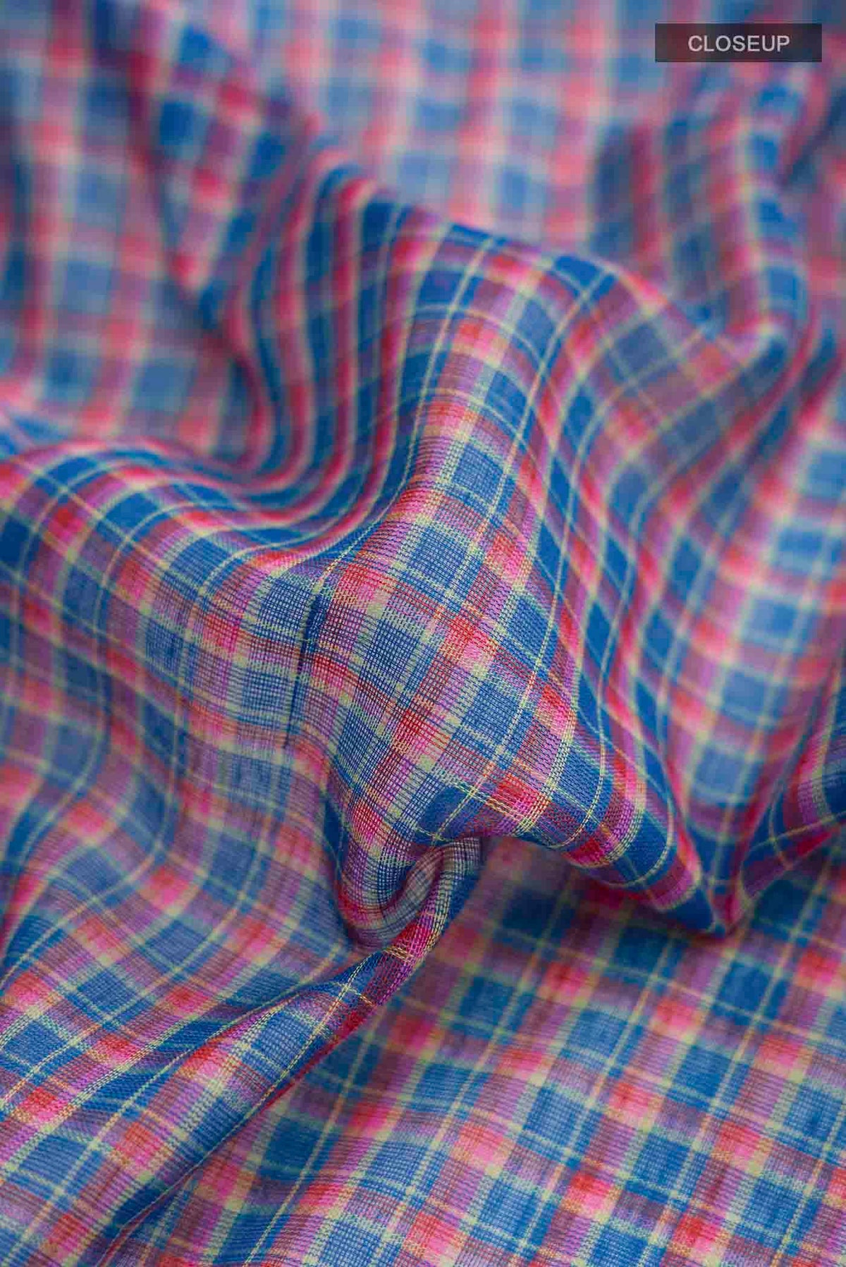 Close up of Patang features fine multi-coloured checks woven using four harmonious hues, creating a lively yet balanced design Translating to ?te)n Hindi, the saree reflects the light, easy spirit of a patang gliding across an open sky The border and pallu are minimal, finished with delicate zari accents that add subtle richness With its balanced play of colour, it makes for a breathable, comfortable drape displaying folds