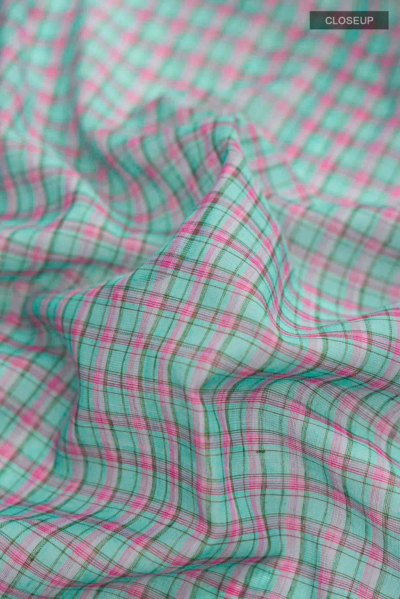 Close up of Patang features fine multi-coloured checks woven using four harmonious hues, creating a lively yet balanced design Translating to ?te)n Hindi, the saree reflects the light, easy spirit of a patang gliding across an open sky The border and pallu are minimal, finished with delicate zari accents that add subtle richness With its balanced play of colour, it makes for a breathable, comfortable drape displaying folds