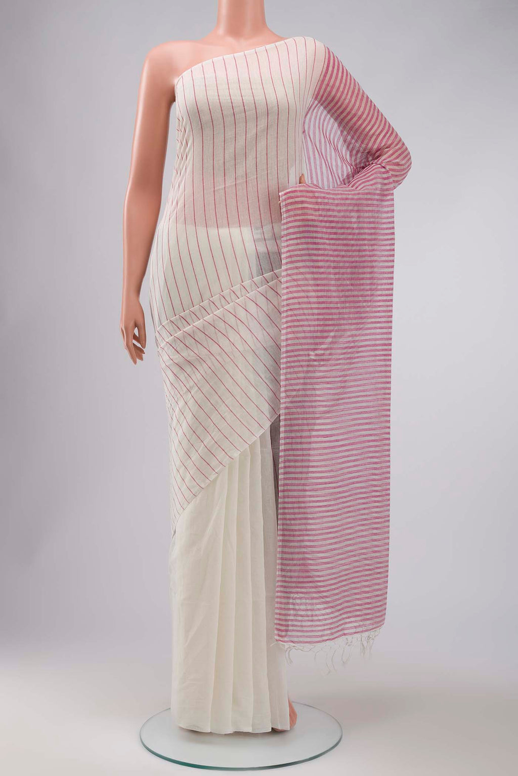 Mogra is designed to feel light and effortless Its muted pastels draw from the soft, fragrant bloom of jasmine, mogra, giving the saree its name Intentional colour-blocking lends it a distinct presence, while contrasting panels shape the pleats and pallu with quiet structure Fine vertical stripes add subtle detail, and silver zari stripes on the pallu offer a gentle, radiant highlight displayed on a mannequin