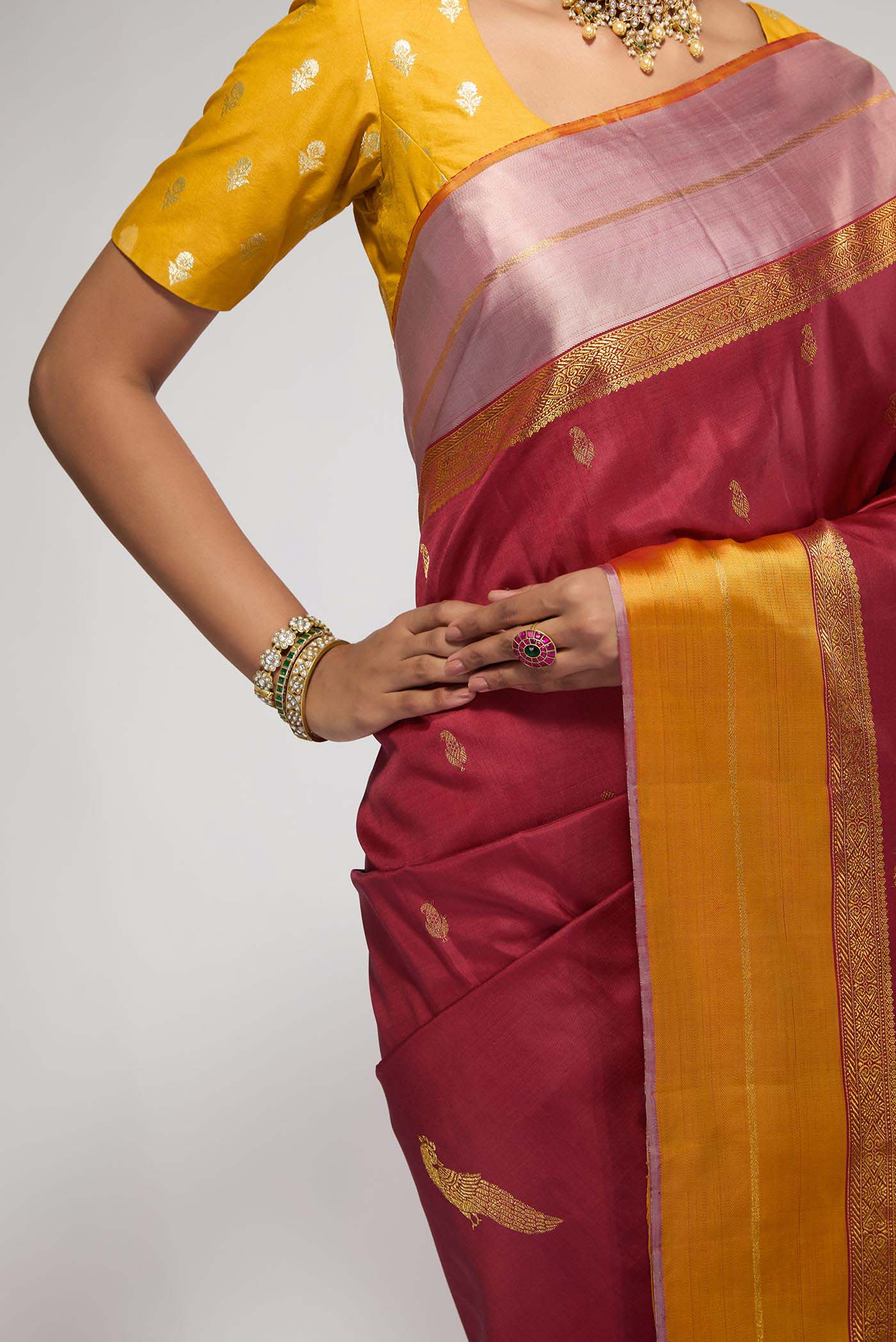 Close up of Pure Silk Pure Zari Maroon Kanchipuram Saree with Zari Butta on the body and Zari Border displaying folds