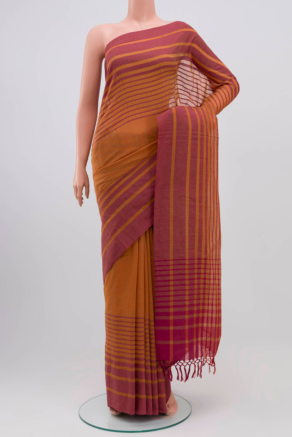 Titli, framed with proportioned stripes that gradually narrow towards the body, bringing together a vibrant palette in harmony Where the border and pallu stripes meet, tiny checks appear, evoking abstract butterflies - delicate creatures of spring and summer The plain body offers soft contrast, allowing the colours to shine On the pallu, these stripes return as subtle checks, adding a light, balanced finish displayed on a mannequin