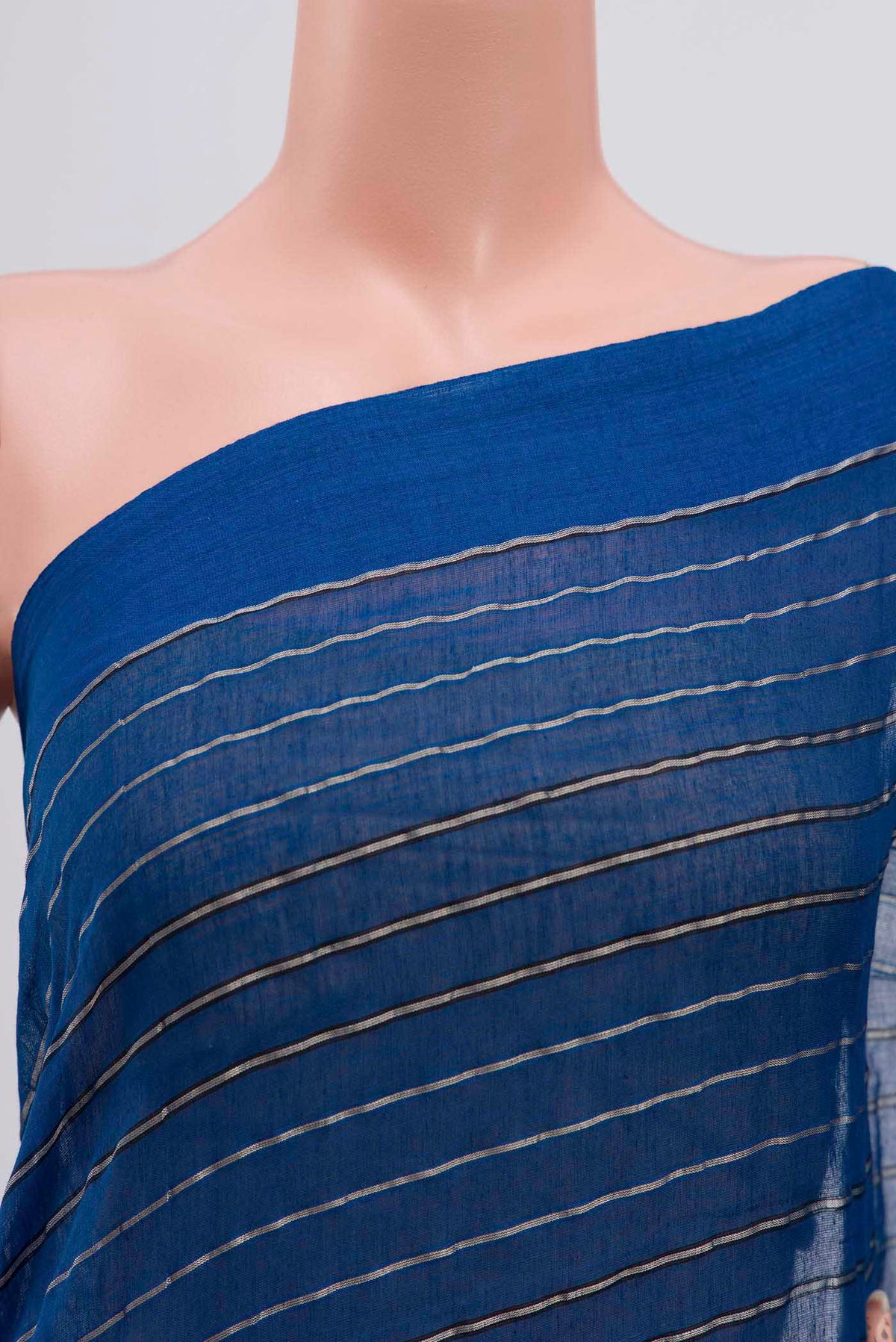 Close up of Mishri, a celebration of summer in Bengal cotton, is woven in fine 60-count cotton and drapes with natural comfort Soft stripes move in gentle linear patterns across the fabric, creating a lively yet balanced design The fine checks they form are a gentle reminder of crystal sugar, lending the saree its name Light, breathable, and effortlessly wearable for sunlit days displaying folds