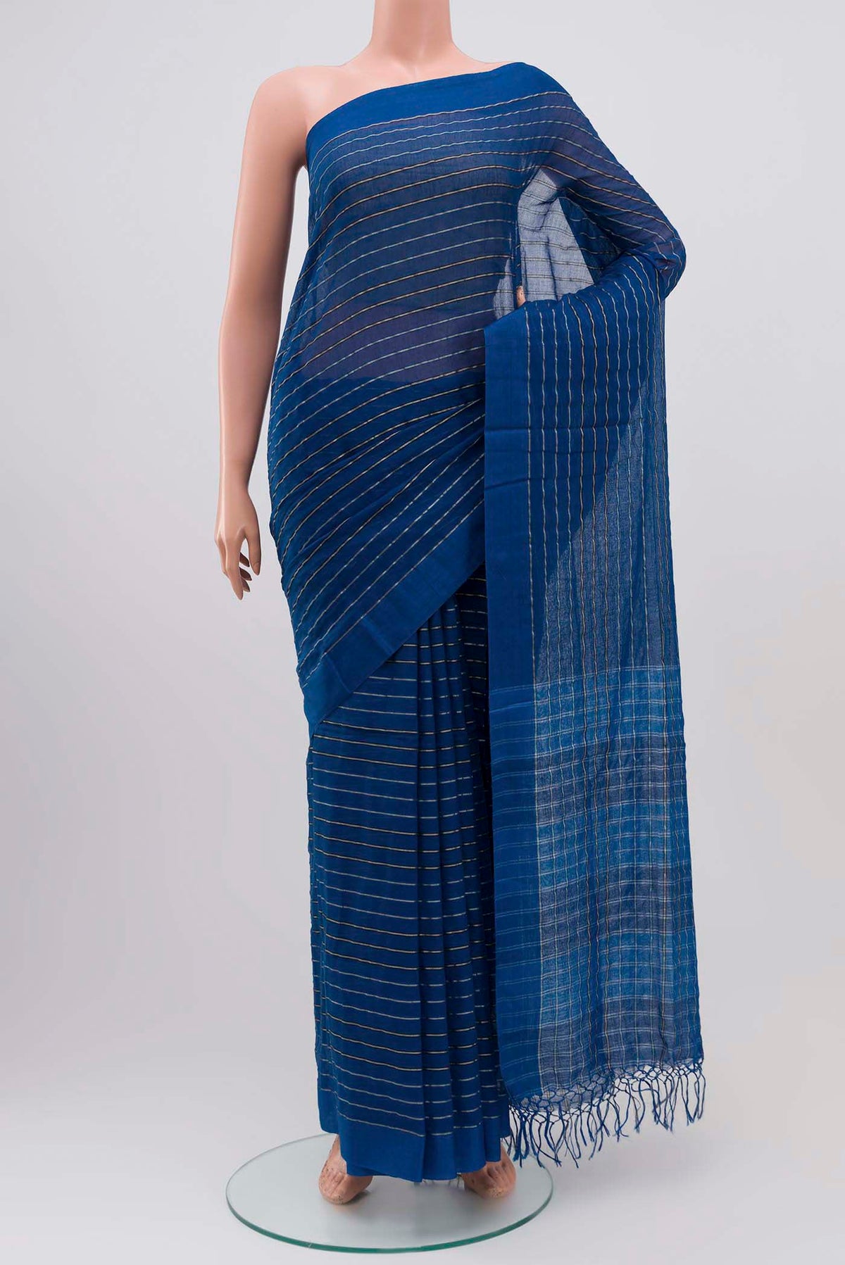 Mishri, a celebration of summer in Bengal cotton, is woven in fine 60-count cotton and drapes with natural comfort Soft stripes move in gentle linear patterns across the fabric, creating a lively yet balanced design The fine checks they form are a gentle reminder of crystal sugar, lending the saree its name Light, breathable, and effortlessly wearable for sunlit days displayed on a mannequin