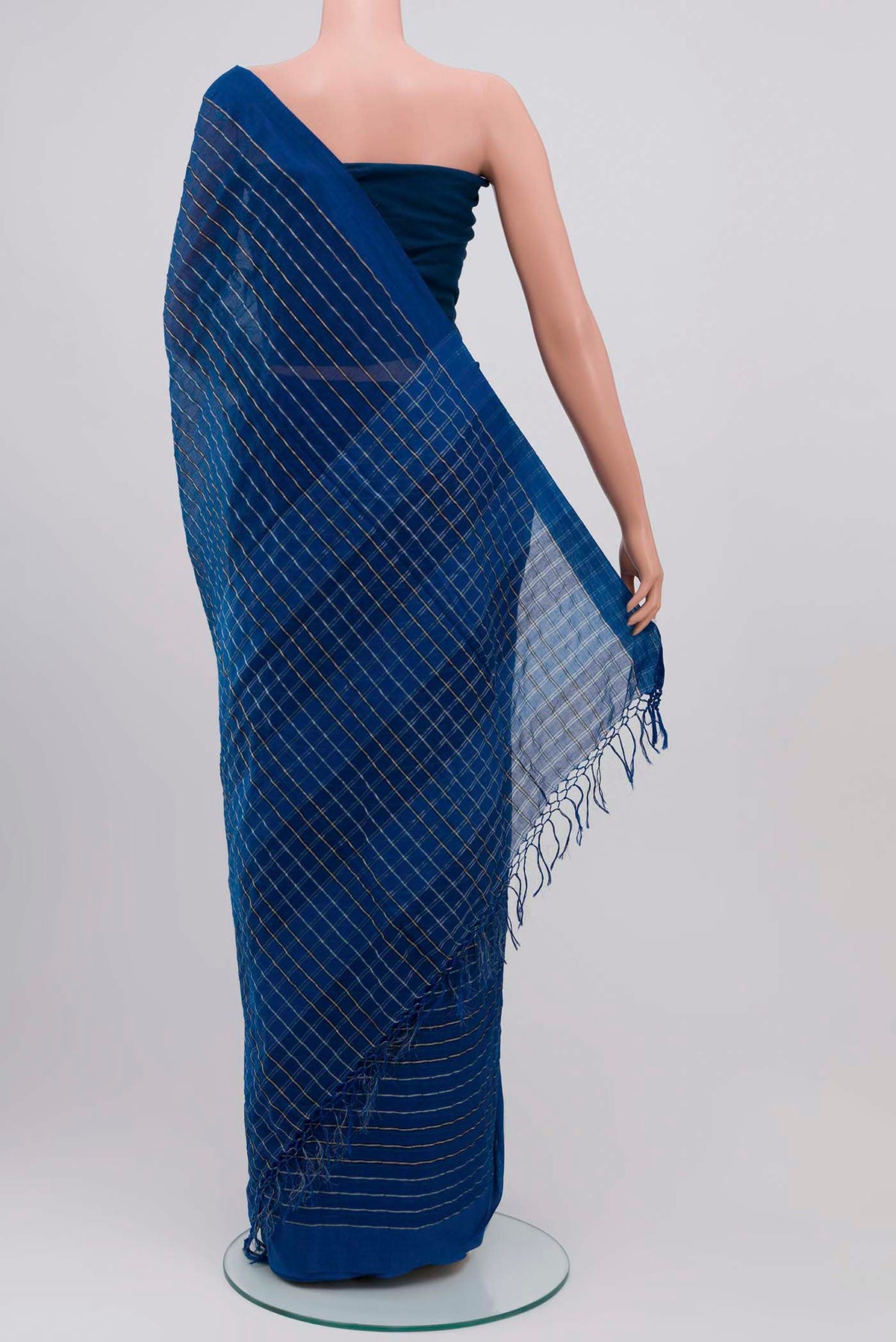 Pleats and pallu of Mishri, a celebration of summer in Bengal cotton, is woven in fine 60-count cotton and drapes with natural comfort Soft stripes move in gentle linear patterns across the fabric, creating a lively yet balanced design The fine checks they form are a gentle reminder of crystal sugar, lending the saree its name Light, breathable, and effortlessly wearable for sunlit days